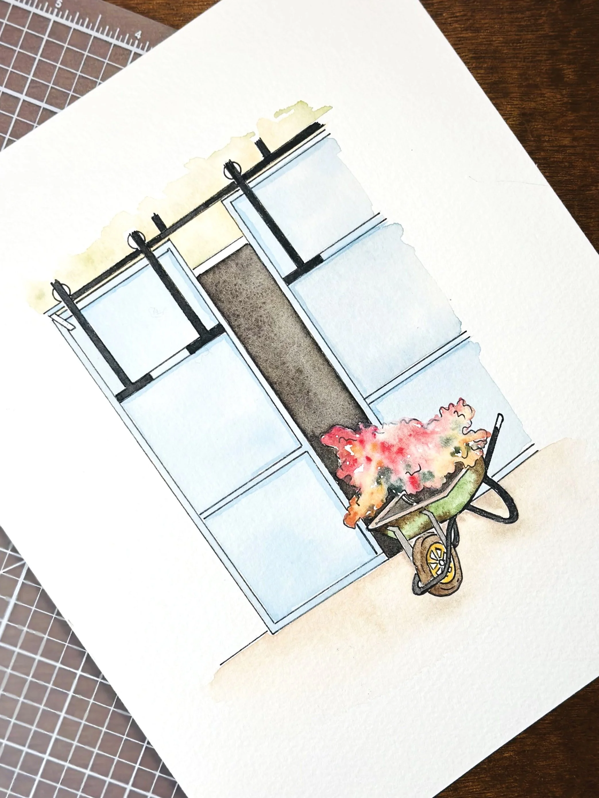 A watercolor painting of a wheelbarrow filled with pink flowers, placed in front of a white shelving unit with glass doors, on a beige surface.