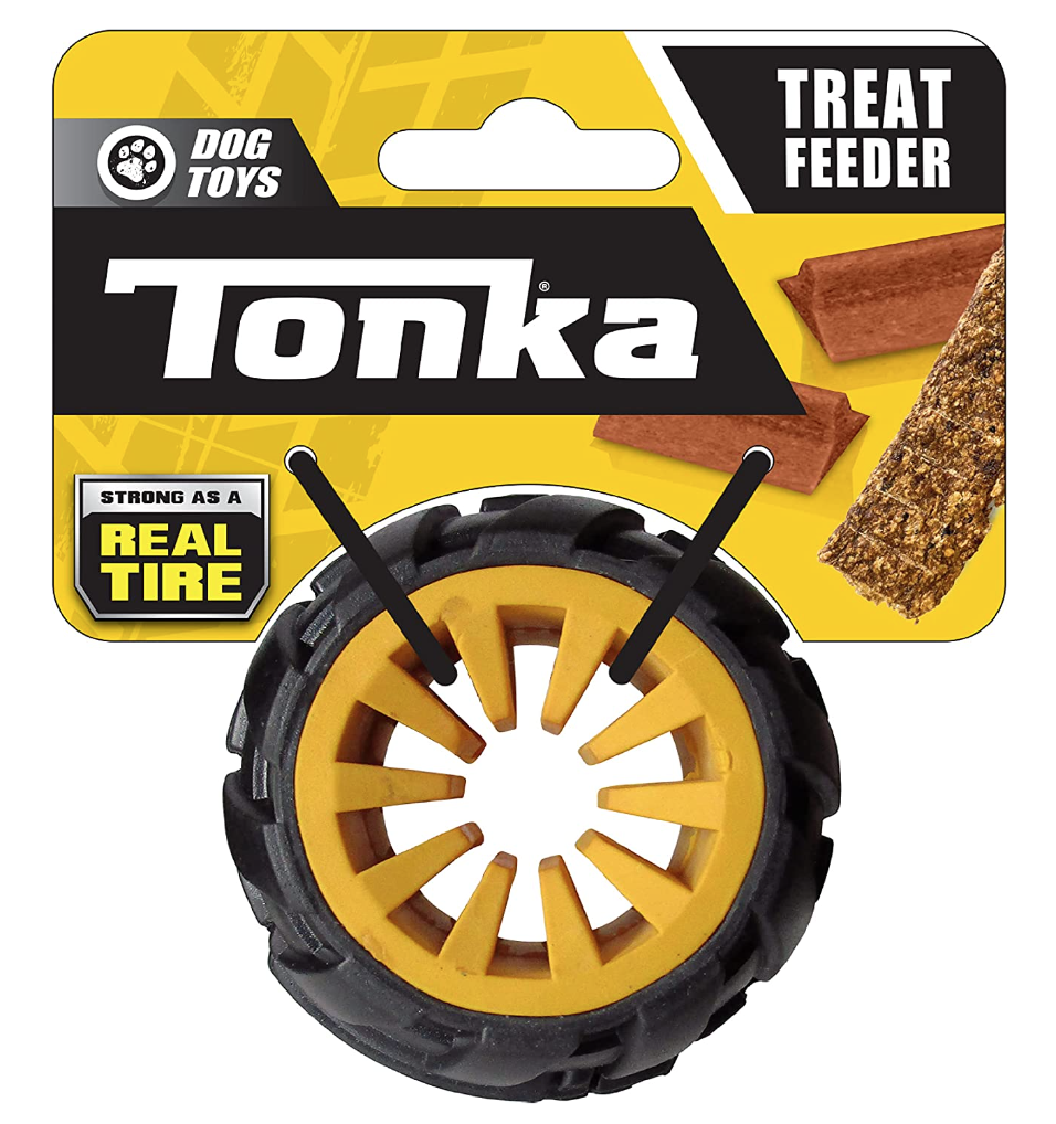 A dog treat feeder shaped like a tire, with two black sticks for tossing, and images of dog treats on the packaging.