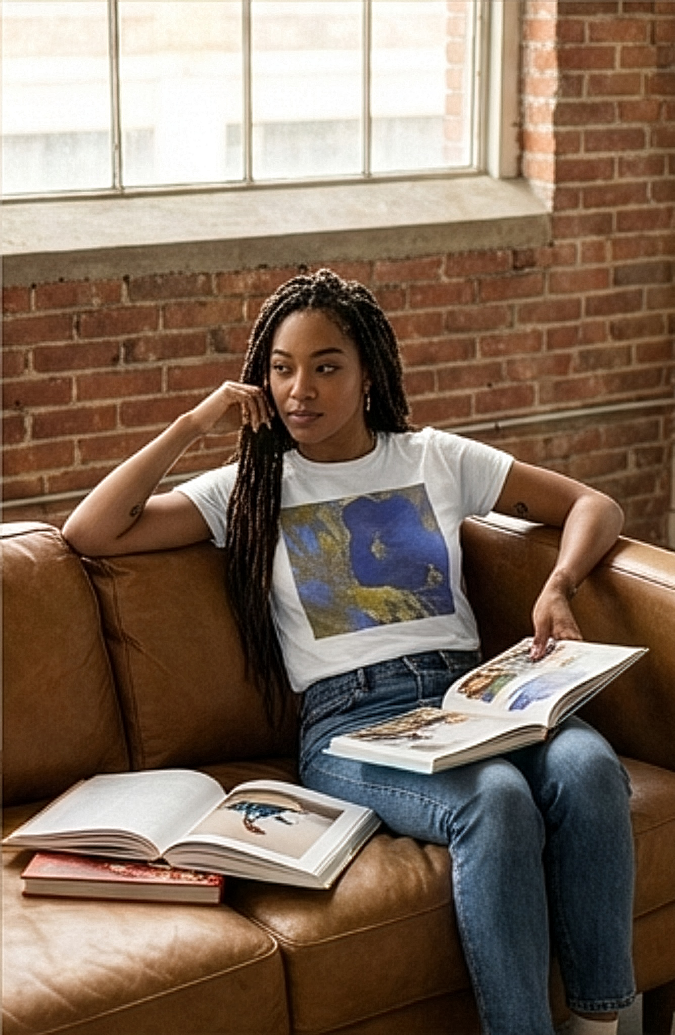 Female model sitting on sofa wearing botanical (hibiscus flower) inspired white t-shirt
