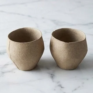 Single yakishime unglazed stoneware cup with organic texture resting on a marble surface in soft natural light