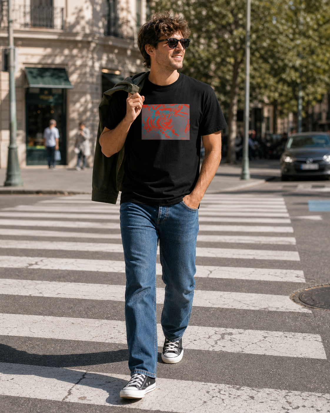 Male model wearing black t-shirt with a rectangular design on the front. The design features a mix of red and teal abstract shapes on a gray background. The shirt is short-sleeved.