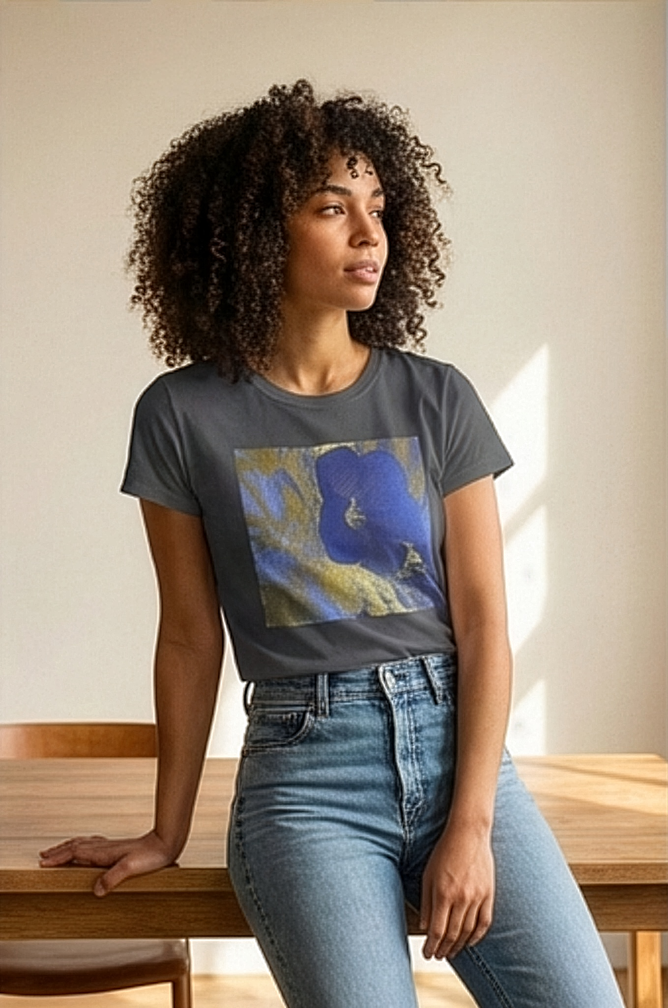 Female model sitting  by the window in a coffee shop wearing botanical (hibiscus flower) inspired charcoal t-shirt