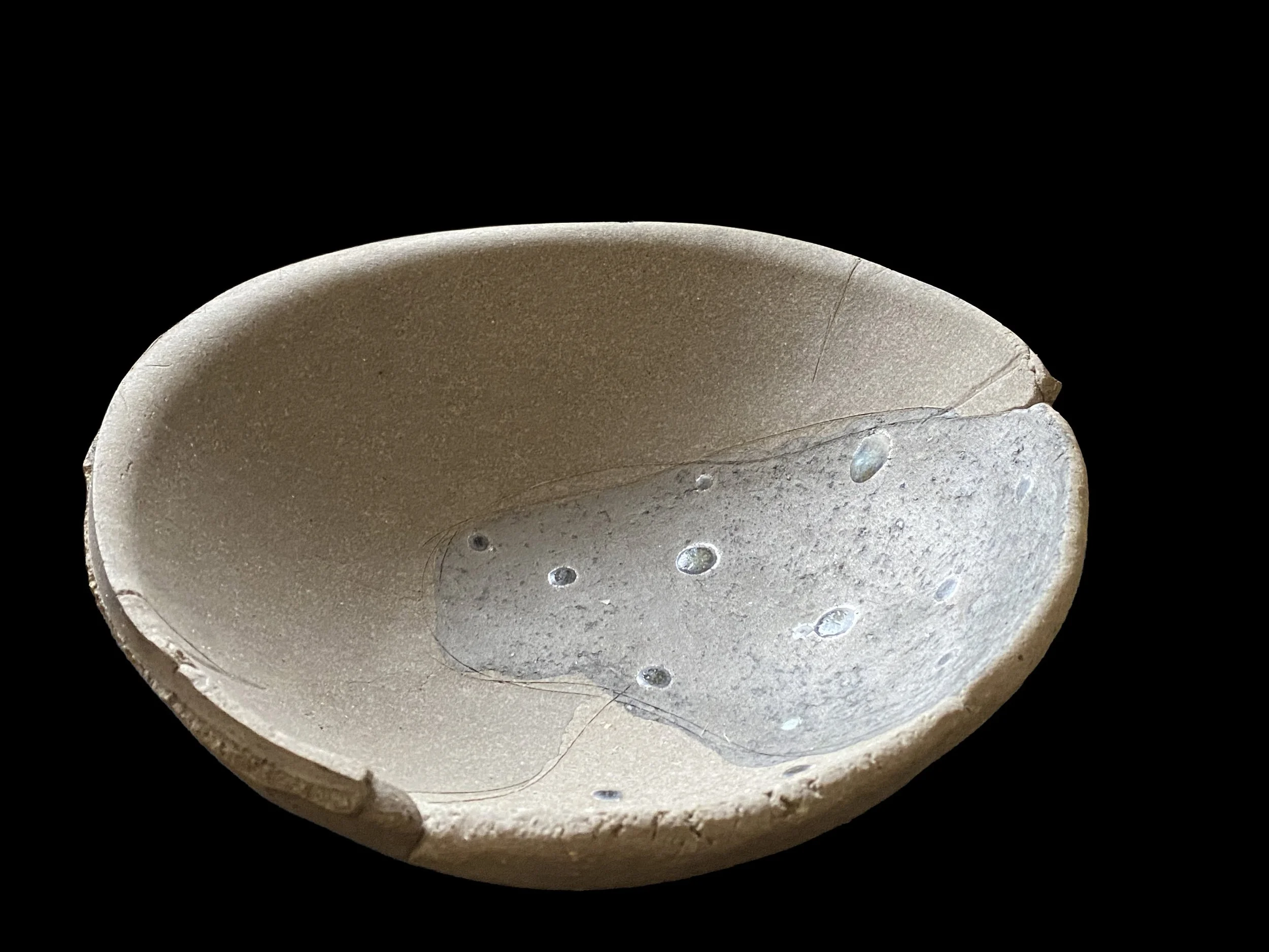 Large yakishime unglazed stoneware bowl with organic ash textures and softly irregular rim, displayed under gallery lighting