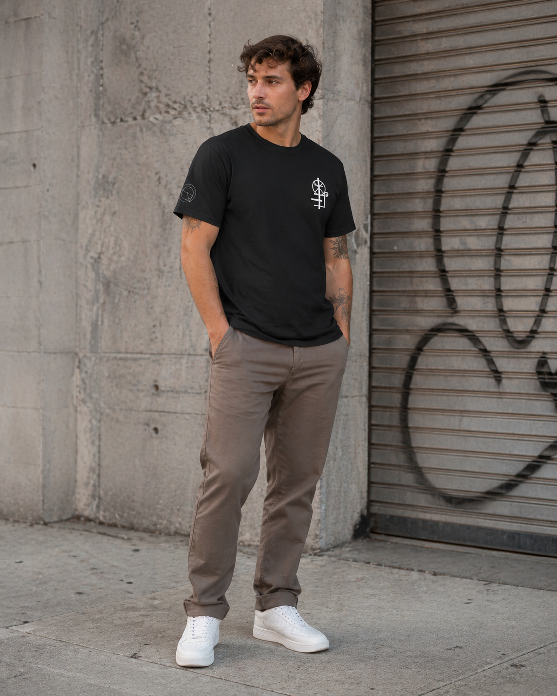 Male model wearing black crew neck t-shirt  with minimal white graphic on the chest. The graphic appears to be a mechanical engineering symbol design.