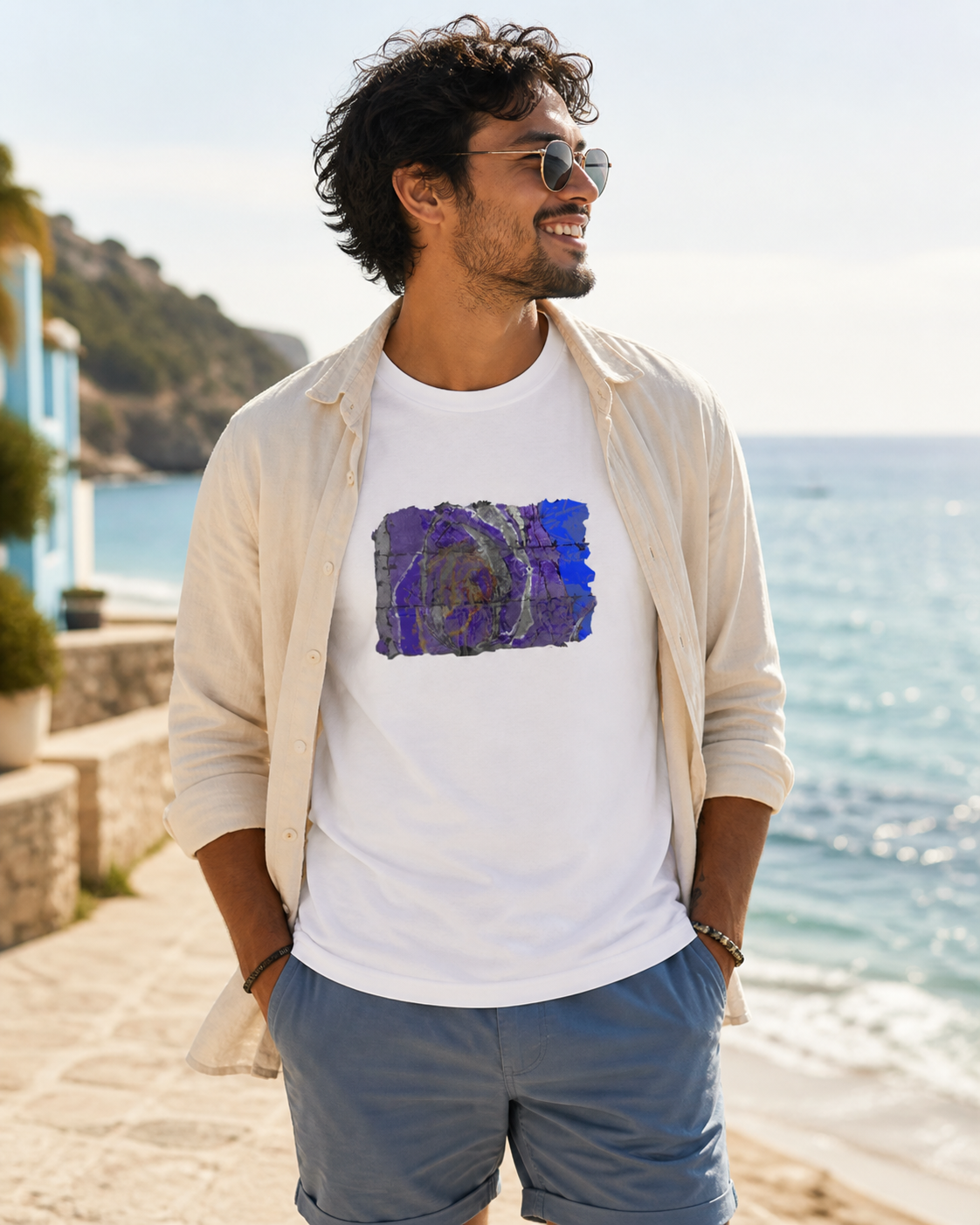 male model wearing white t-shirt of vivid shades of purple, blue, gold, and charcoal abstract art