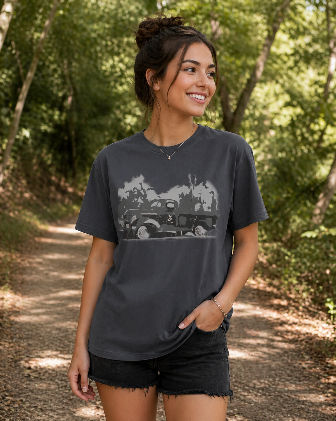 Female model wearing vintage car graphic t-shirt featuring monochrome classic automobile illustration on dark grey shirts.