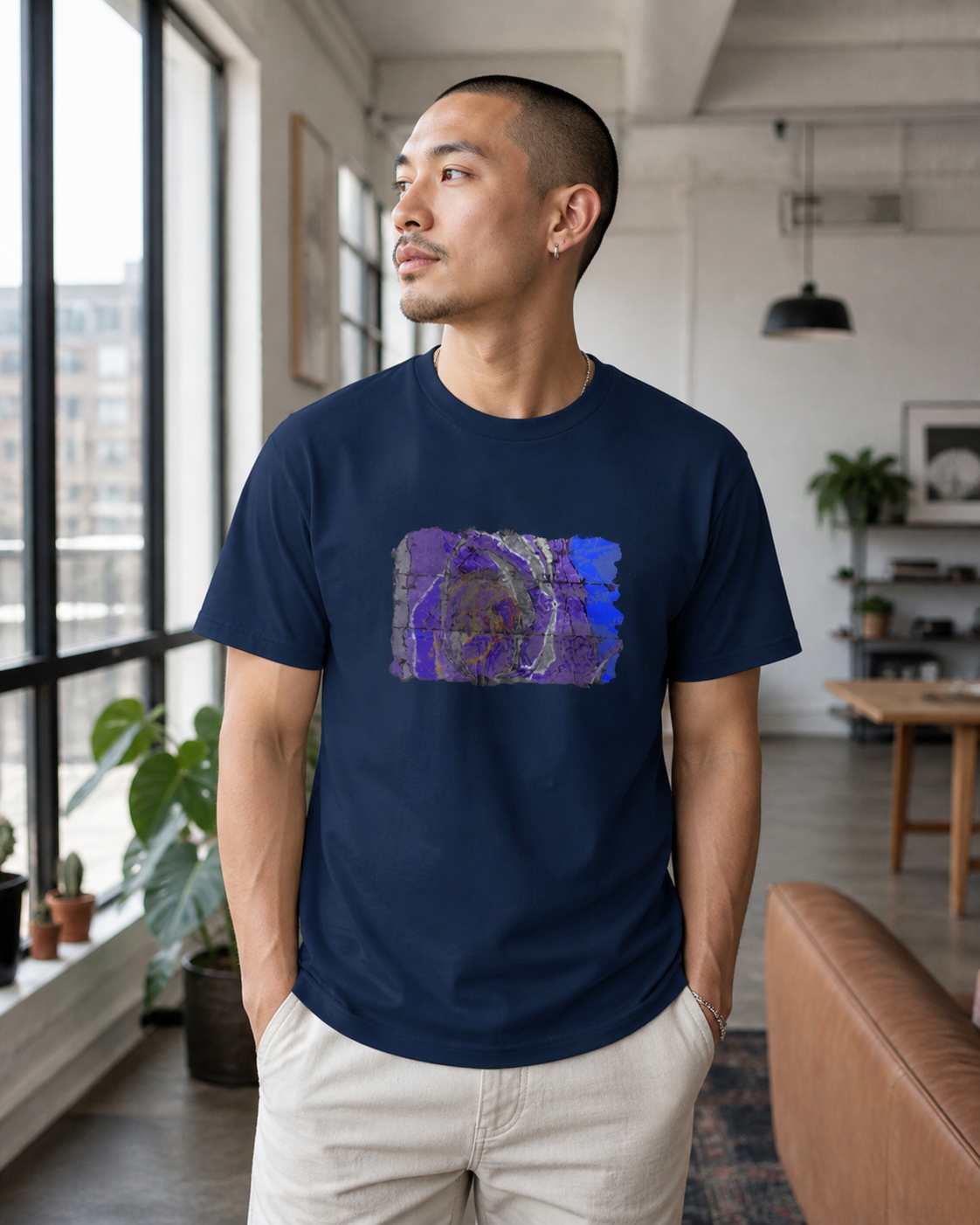male model wearing navy t-shirt of vivid shades of purple, blue, gold, and charcoal abstract art