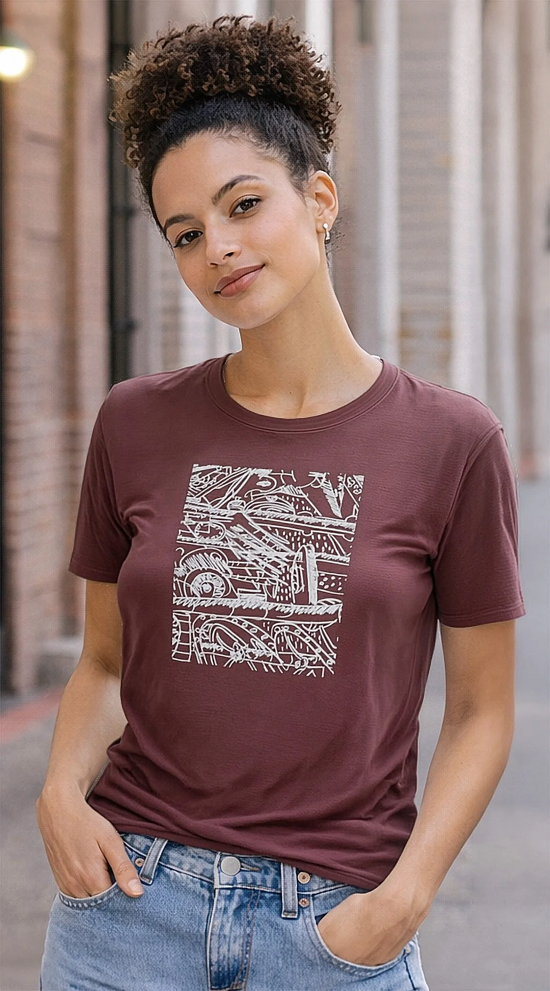 Female model wearing maroon t-shirt featuring a white abstract design. The graphic is a complex arrangement of lines, shapes, and numbers. The short-sleeved shirt is made of a soft material.