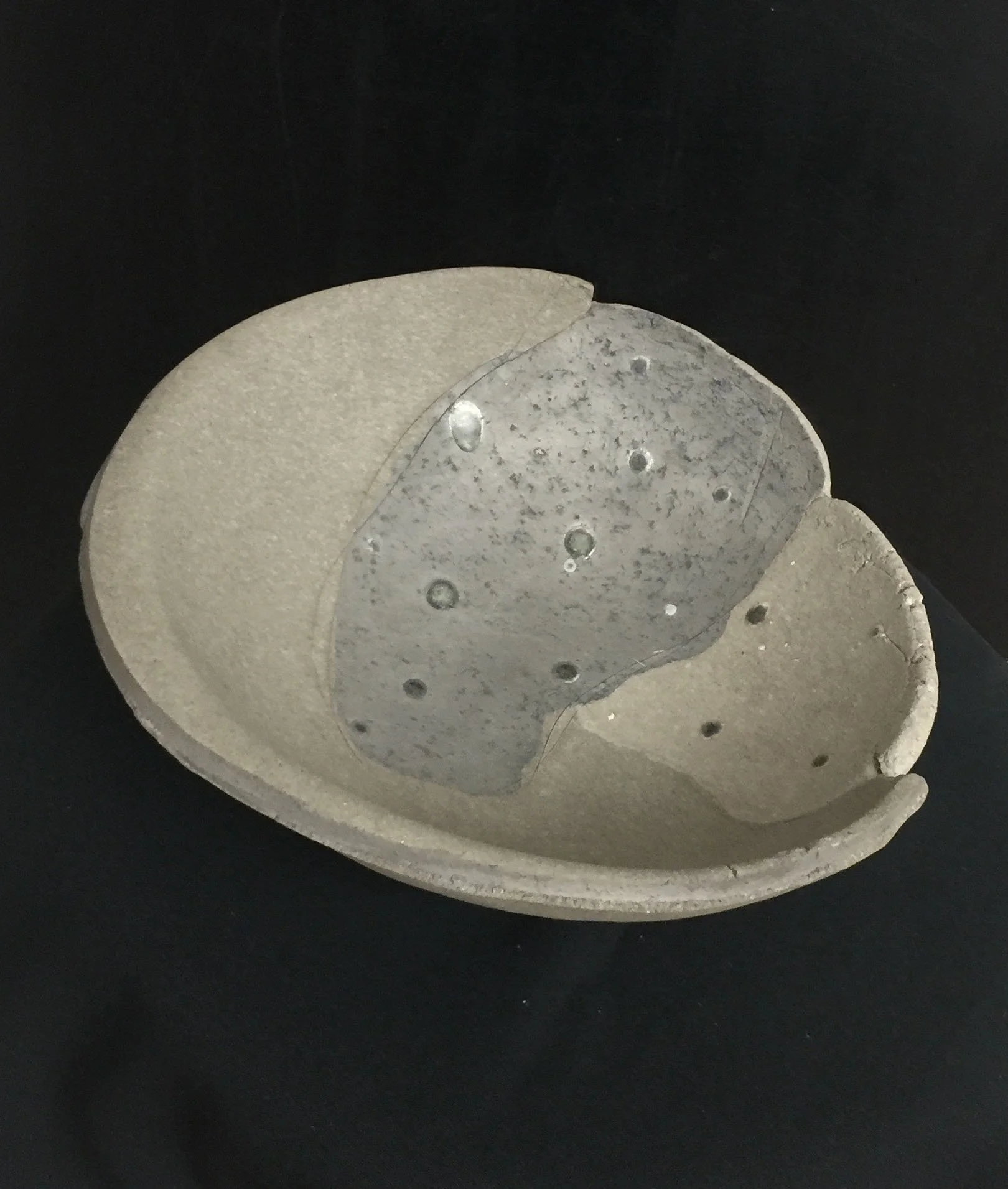 Large yakishime unglazed stoneware bowl with organic ash textures and softly irregular rim, displayed under gallery lighting