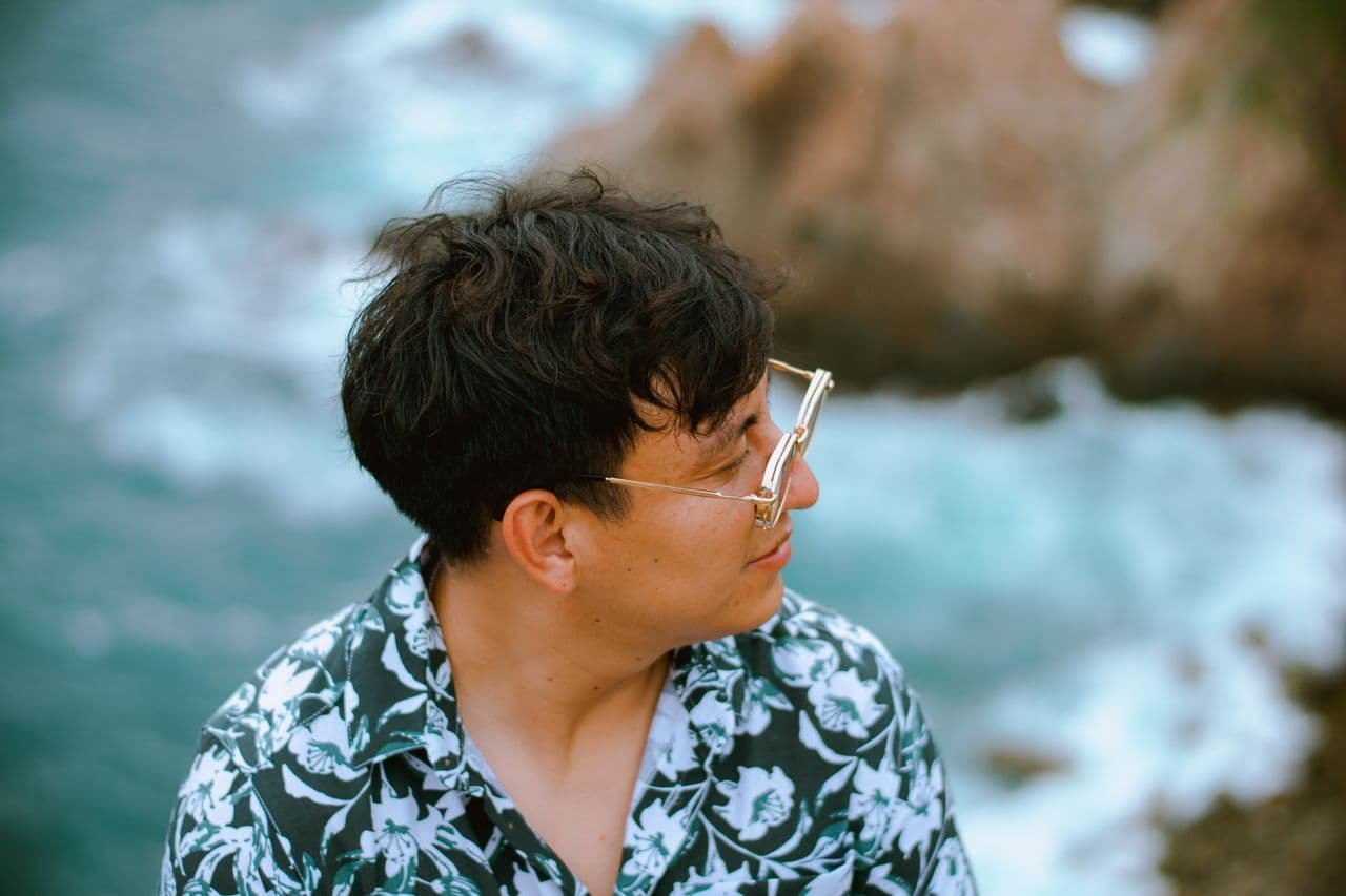 man-with-glasses-overlooking-scenic-ocean-view