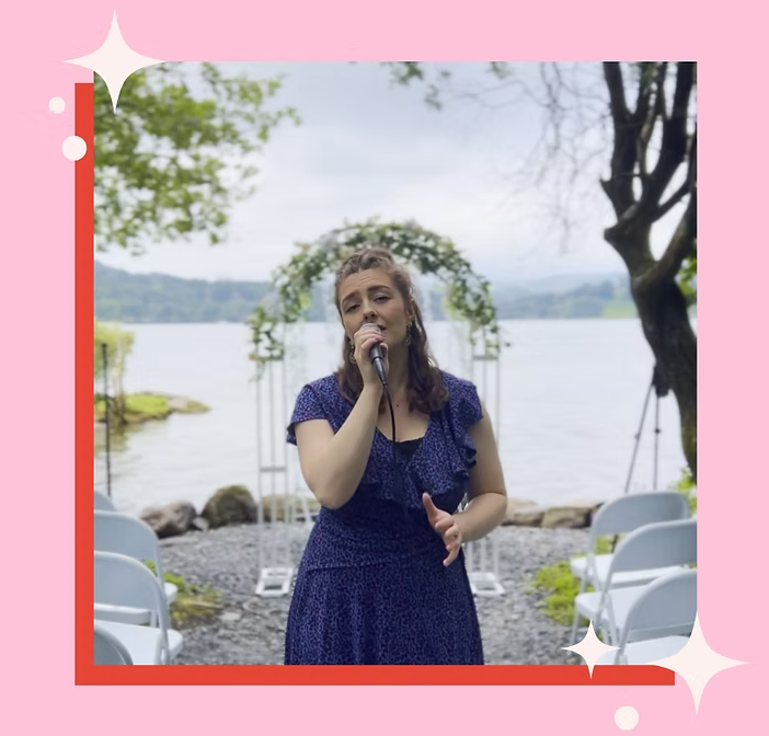 Jess Hawkins singing into a microphone at a wedding