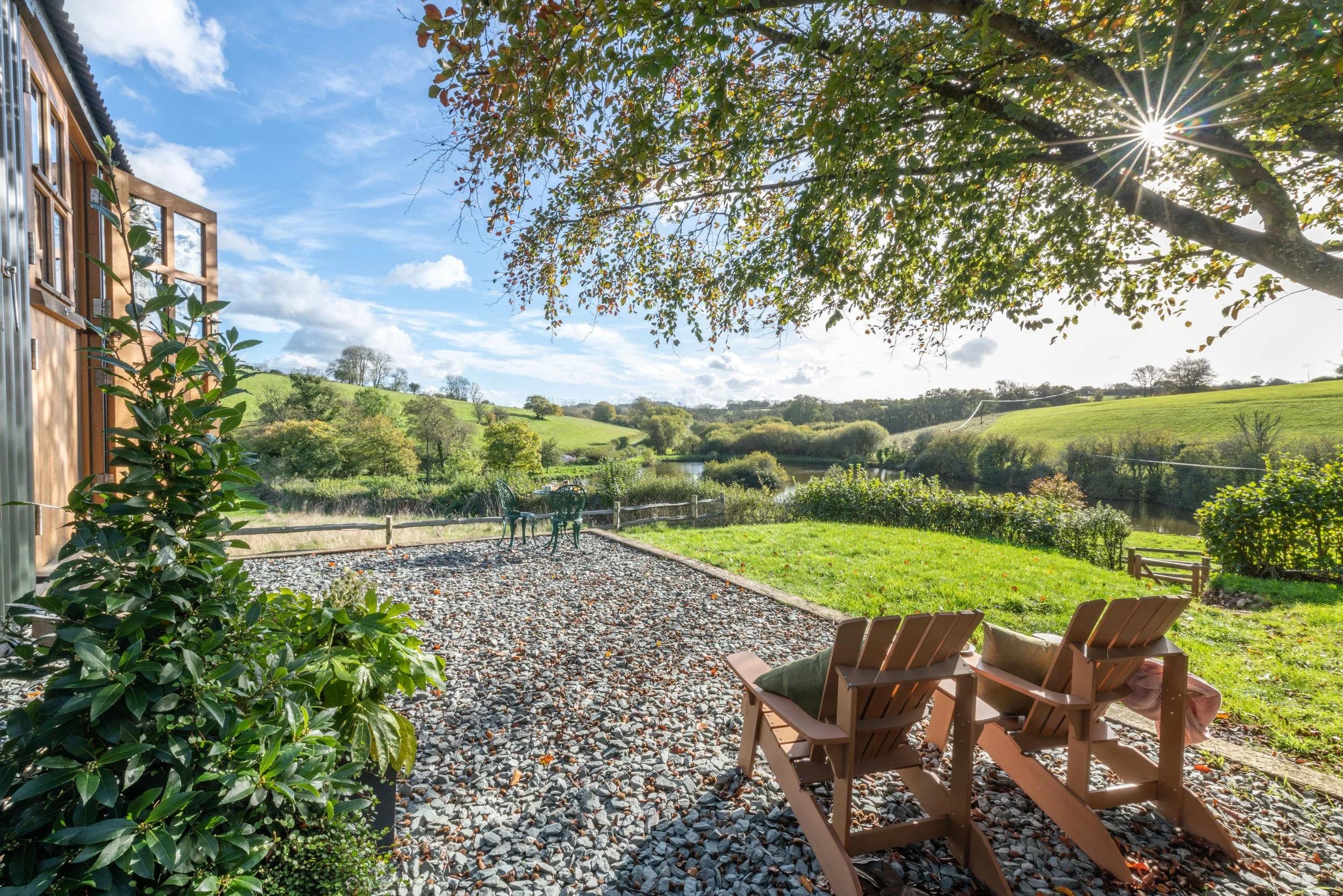 Peaceful lake view seen from the doorway of a shepherd's hut holiday let.