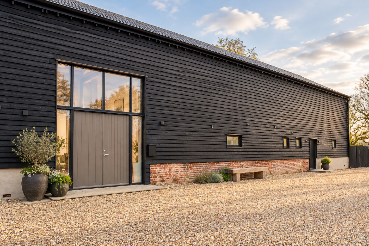 Talbots Barn, Poslingford: the black weatherboarded Grade II listed barn with its full-height glazed entrance