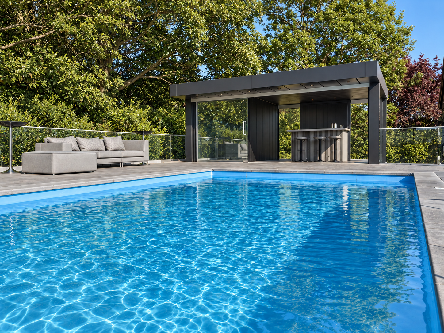 New-build pool house and swimming pool at The Barn, Essex: dark-clad pool house with glazed sliding doors and outdoor bar, beside a stone-edged pool and terrace