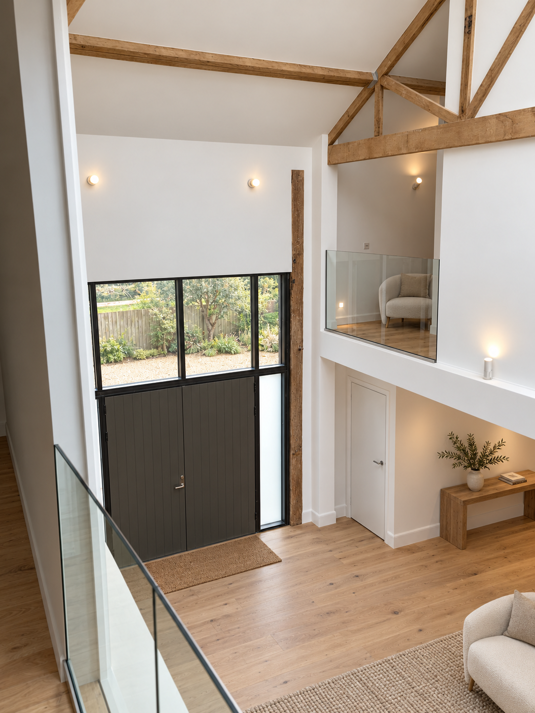 Double-height entrance hall with oak frame and glazed gallery at Talbots Barn, a Grade II listed barn in Poslingford, Suffolk