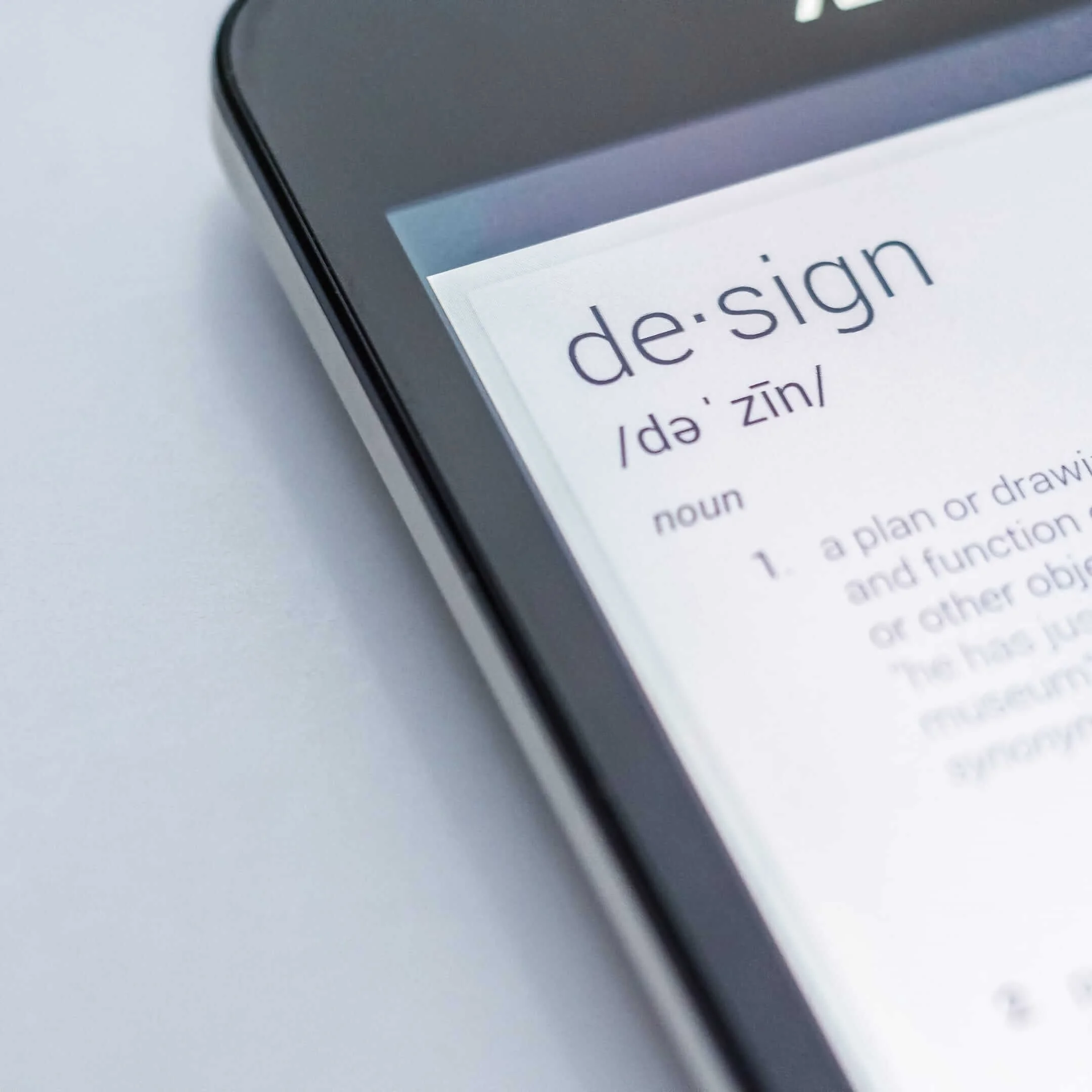Close-up of a smartphone screen displaying the definition of the word 'design' from a dictionary app.