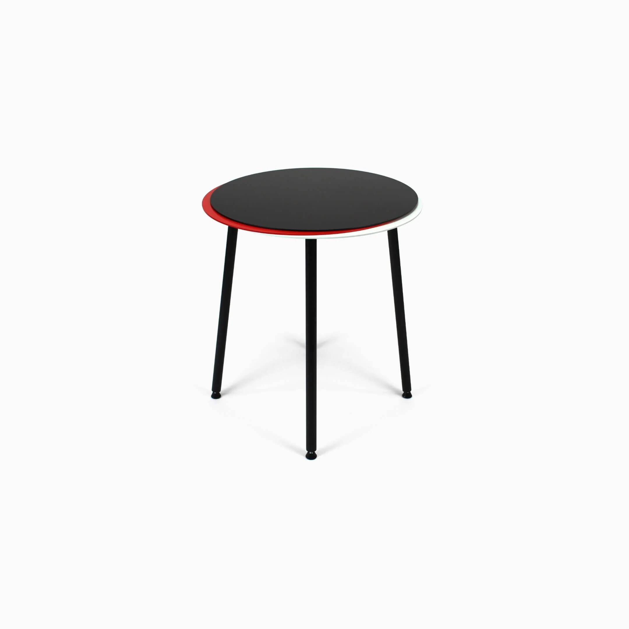 A Stacked side table in steel. The body is in black, with red and white detail in the two additional tabletops.