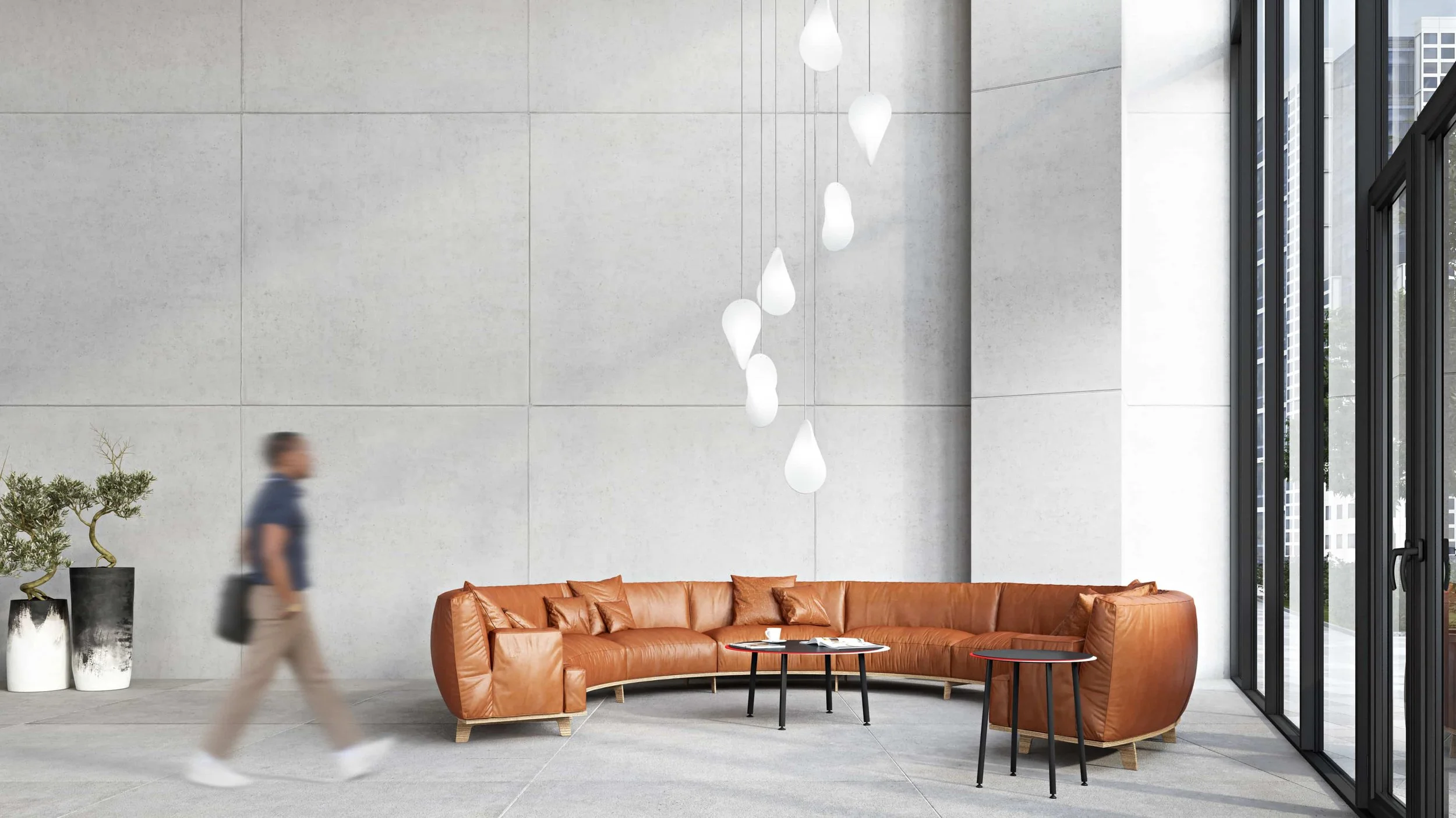 Oh Lloyd! pendant lights in a spiral arrangement, hung in the lobby of a commercial interior. The lights have silver cable flex and brushed stainless steel fixings.