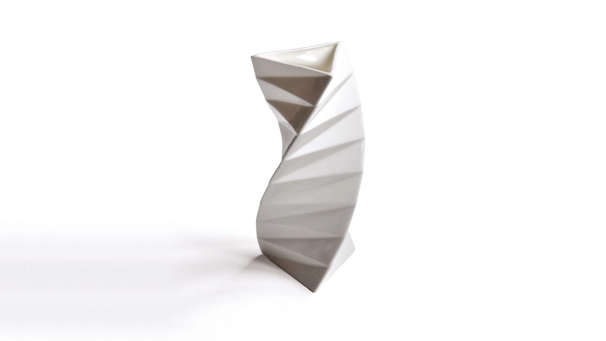 The Orishe bone china vase. Light reflecting off its facetted, twisting form creates a beautiful interplay of light and dark surfaces.