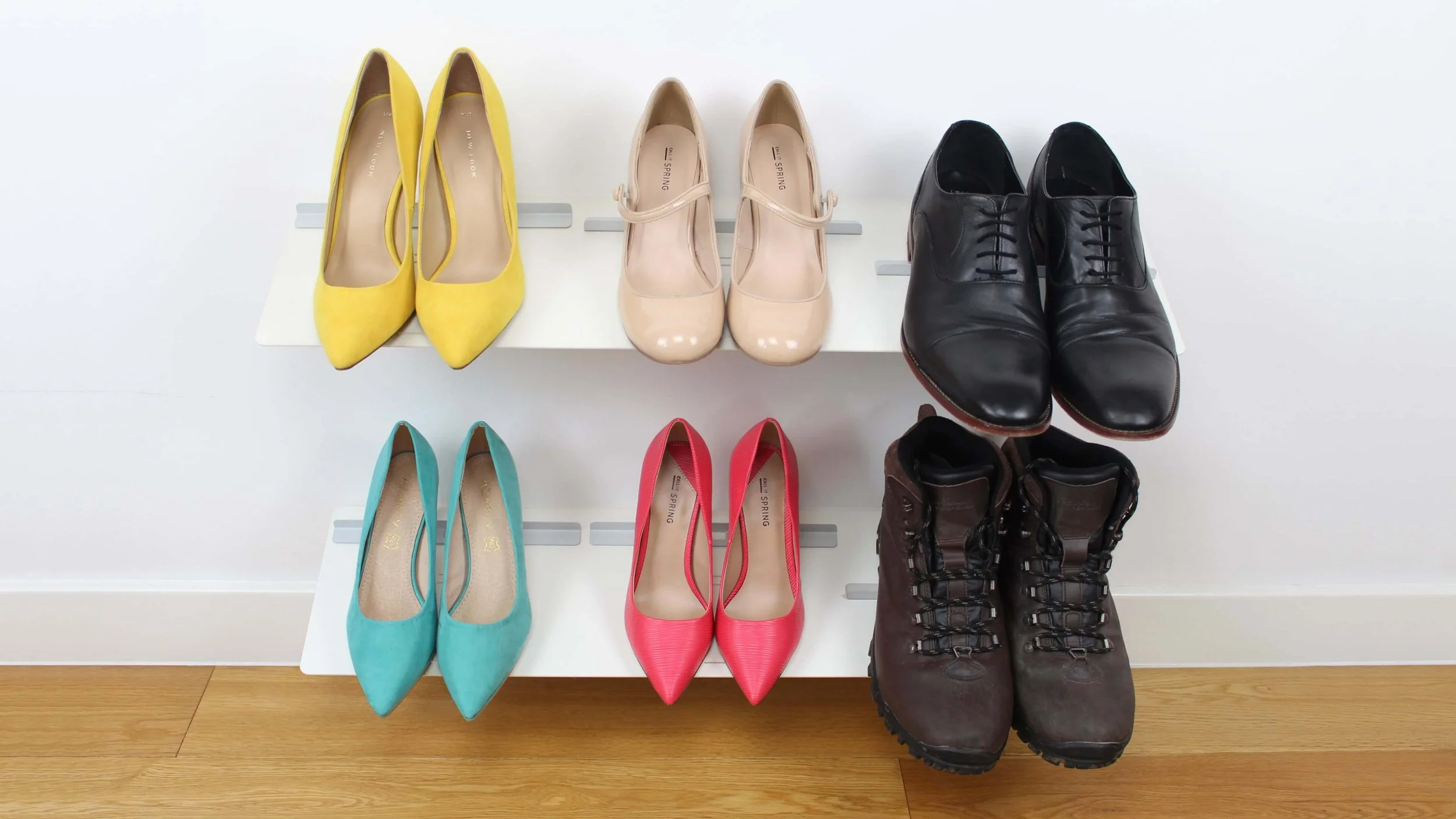Two Versa wall-mounted shoe racks holding a variety of different shoe types and sizes in a tidy and space efficient manner.