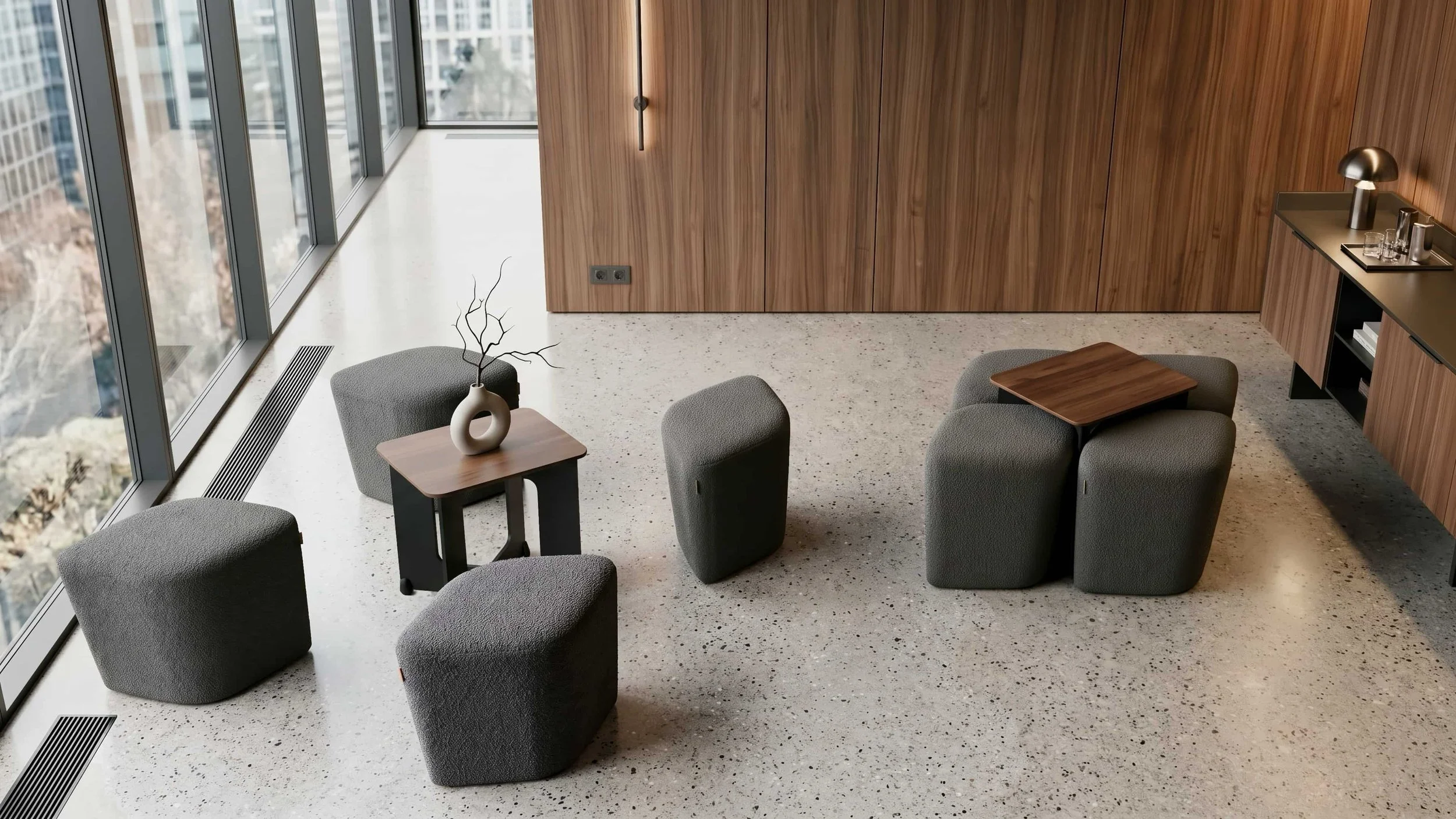 Two Rhombic Seating Systems with grey poufs and Walnut tables adorn a communal area in a high-end commercial space.