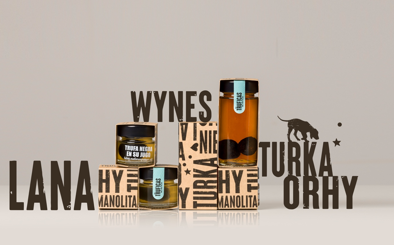 Three small jars of honey with black lids and labels reading "Trufa Negra En Su Jugo" and "Trufas" are displayed among cardboard boxes with text including "Wynes," "TURKA," and "LANA." A cartoon of a dog is also present.