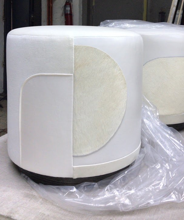 White Decoupage upholstered cylindrical stools with a wooden base, as they are ready to ship.