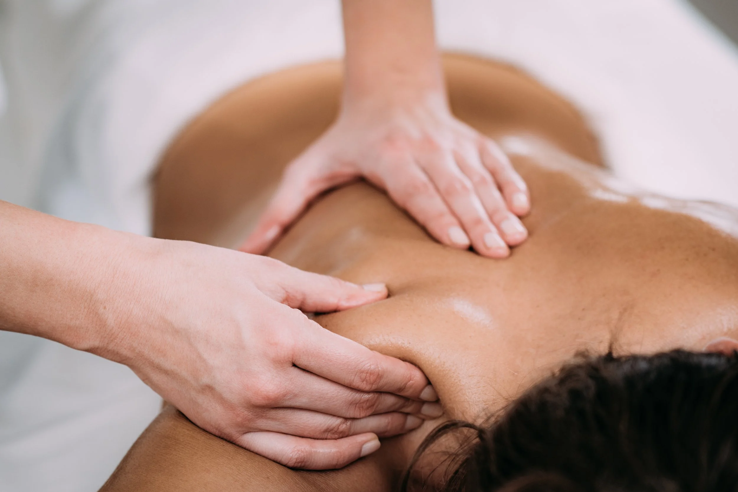 A person receiving a massage on their back from a massage therapist.