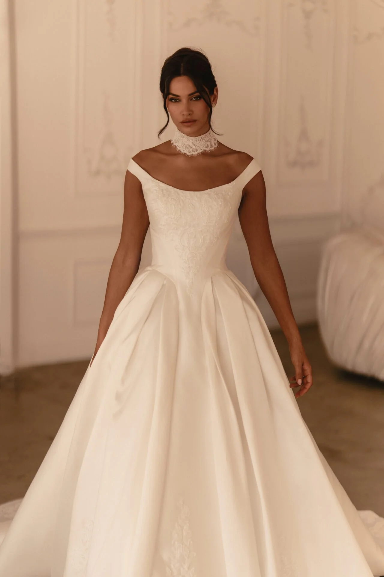 A woman trying on a wedding dress in a luxurious room.