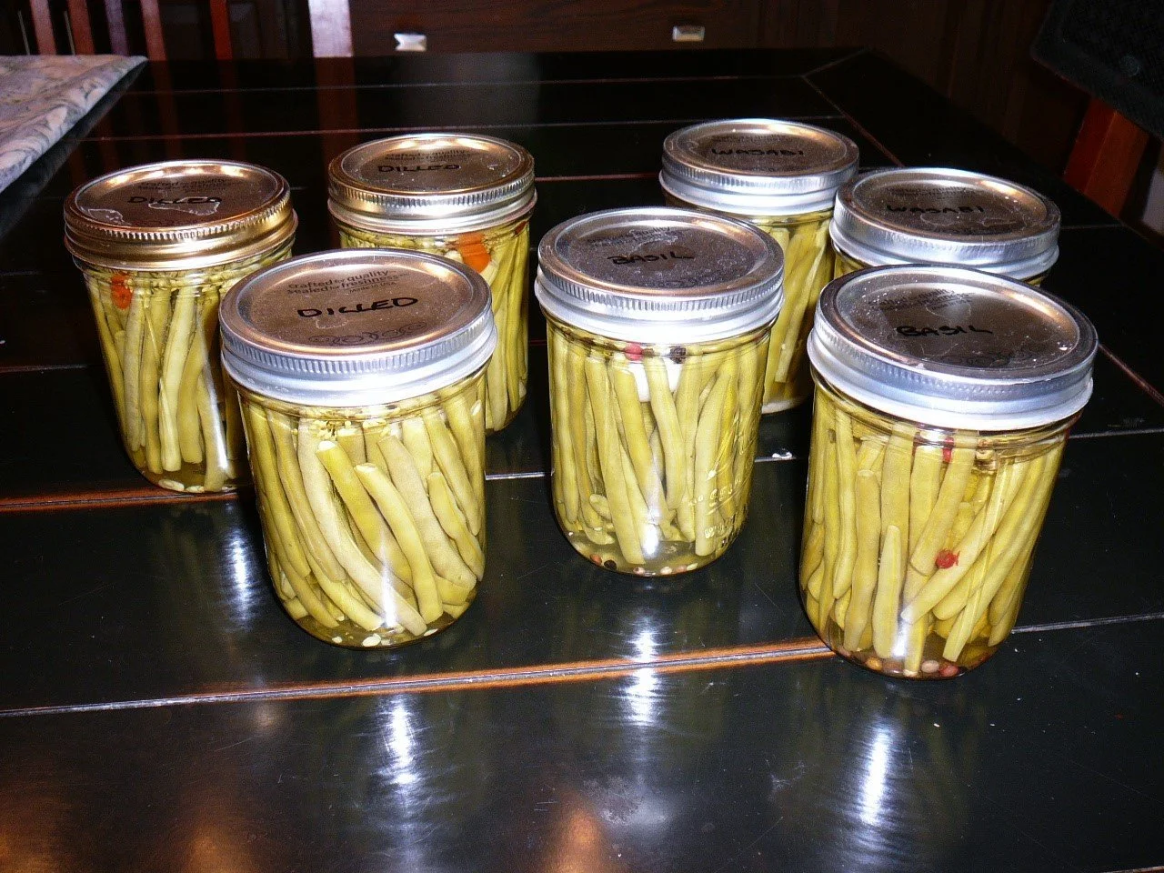 Pickled dilly beans in jars sitting on a counter