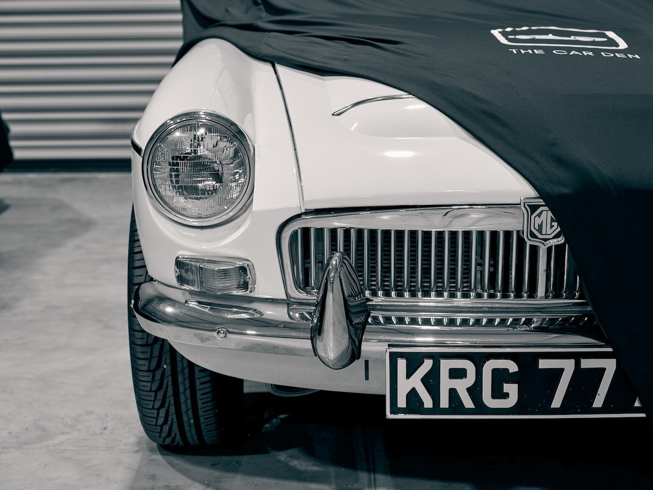 White MG with a Car Den branded cover being lifted in Covered Outdoor storage
