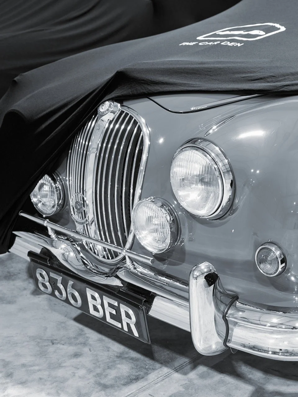 Jaguar Mk2 grille and headlamps with a Car Den branded cover partly lifted
