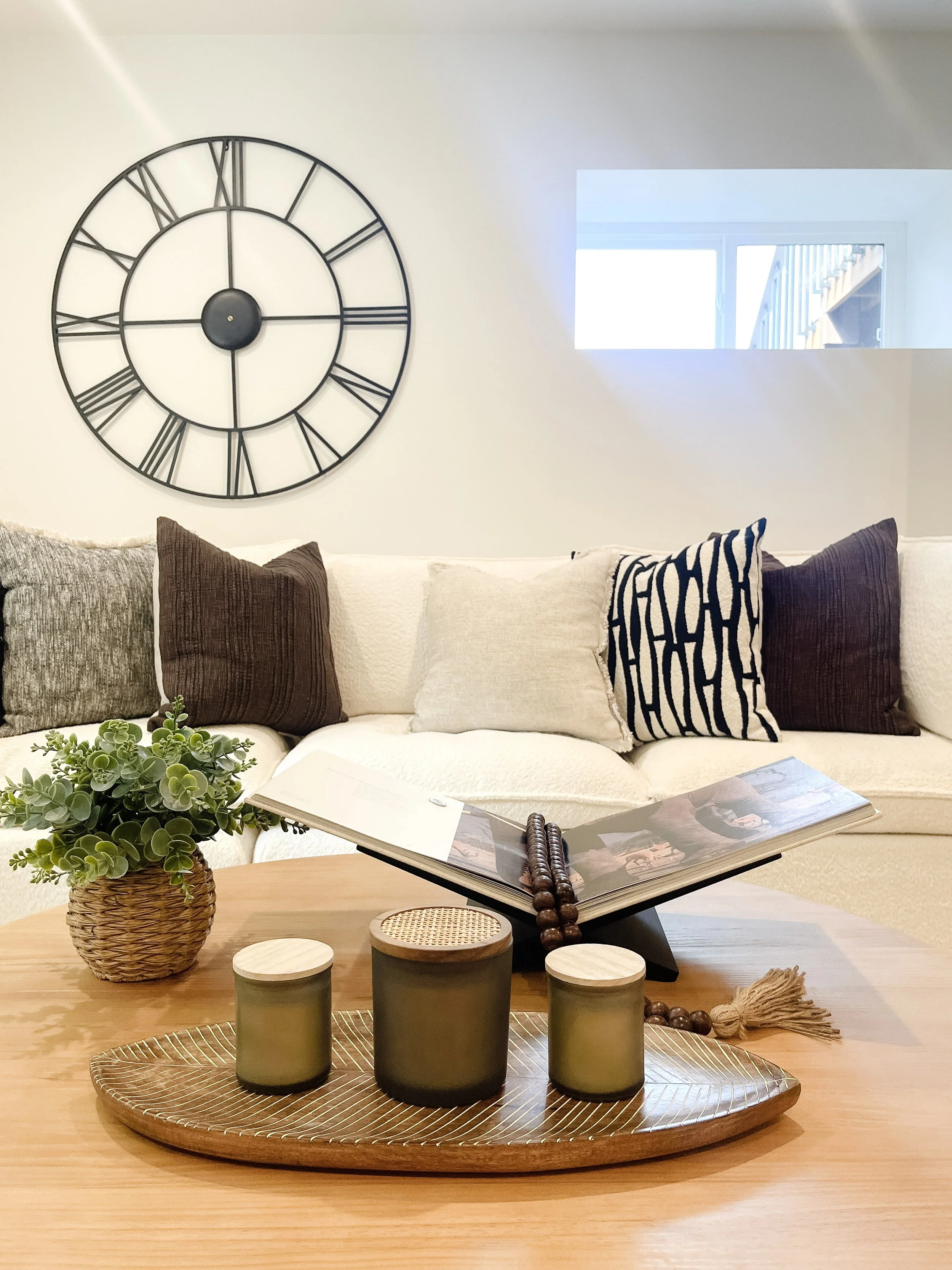 A modern coastal living room staged in a Camano Island home, featuring neutral furniture, layered textures, and bright natural light.
