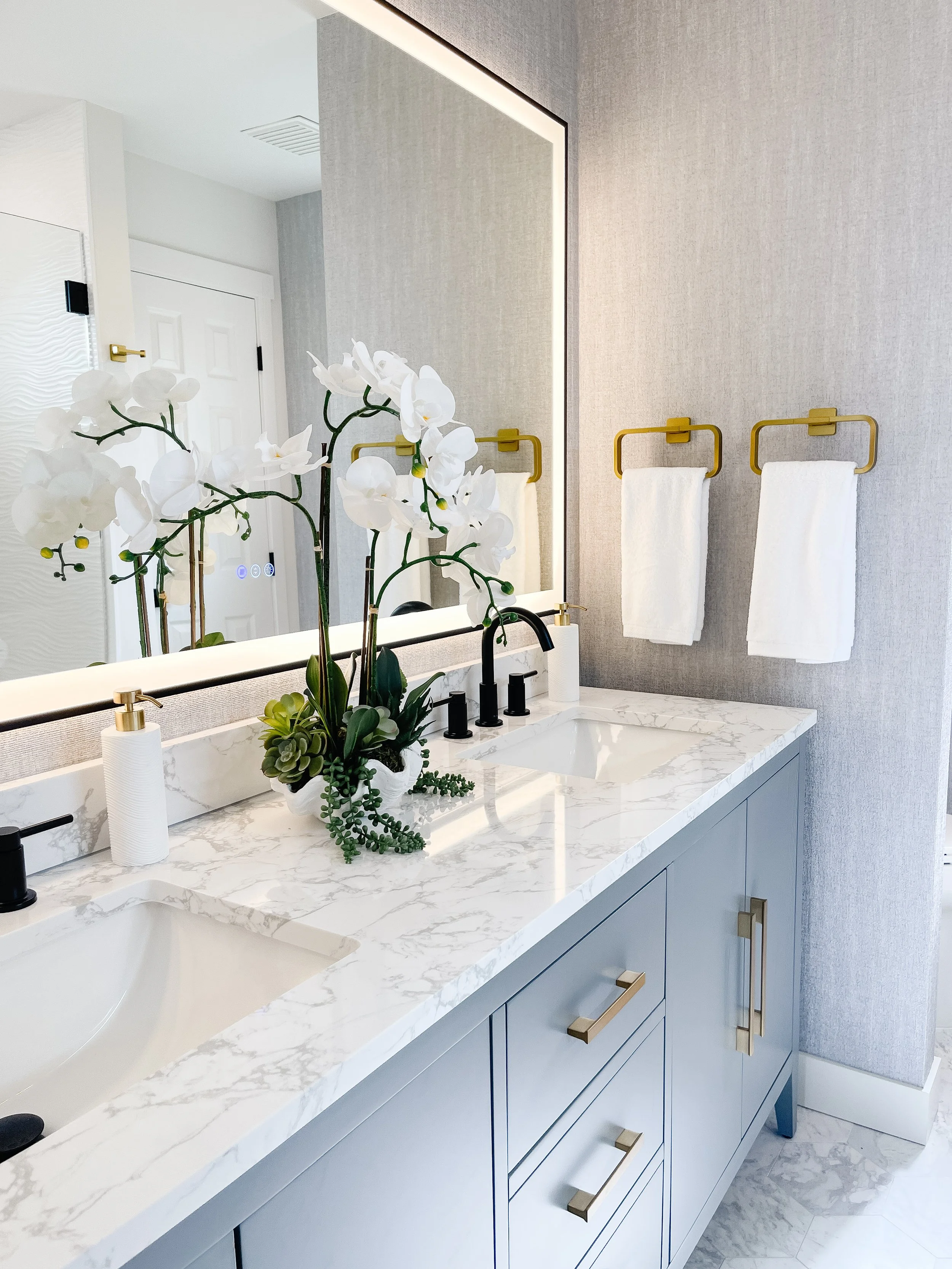 Spa-inspired staged bathroom in a Camano Island home with fresh white towels, greenery, and simple decor.