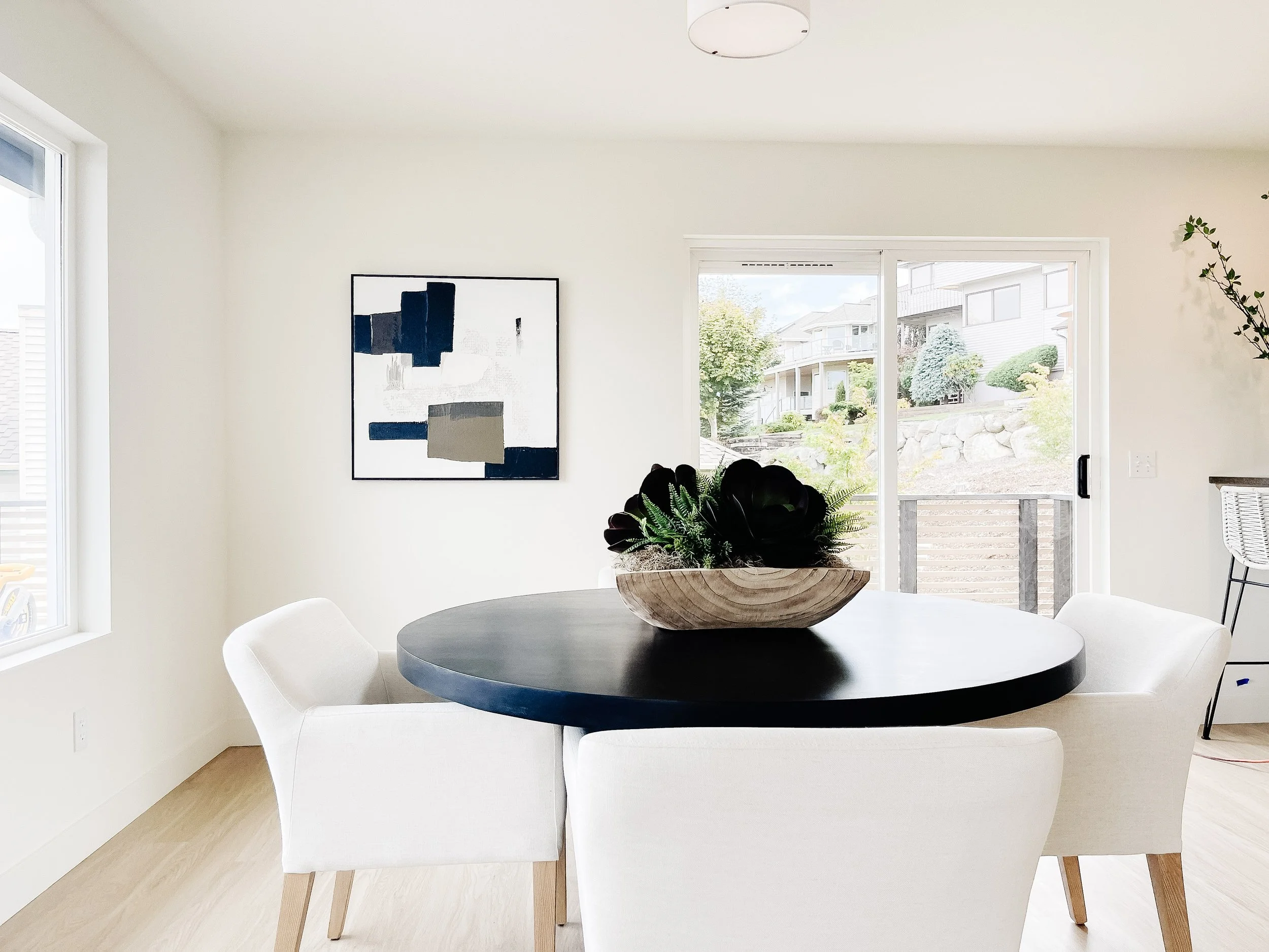 Open concept Camano Island kitchen and dining room professionally staged with warm wood table, upholstered chairs, and coastal-inspired decor.