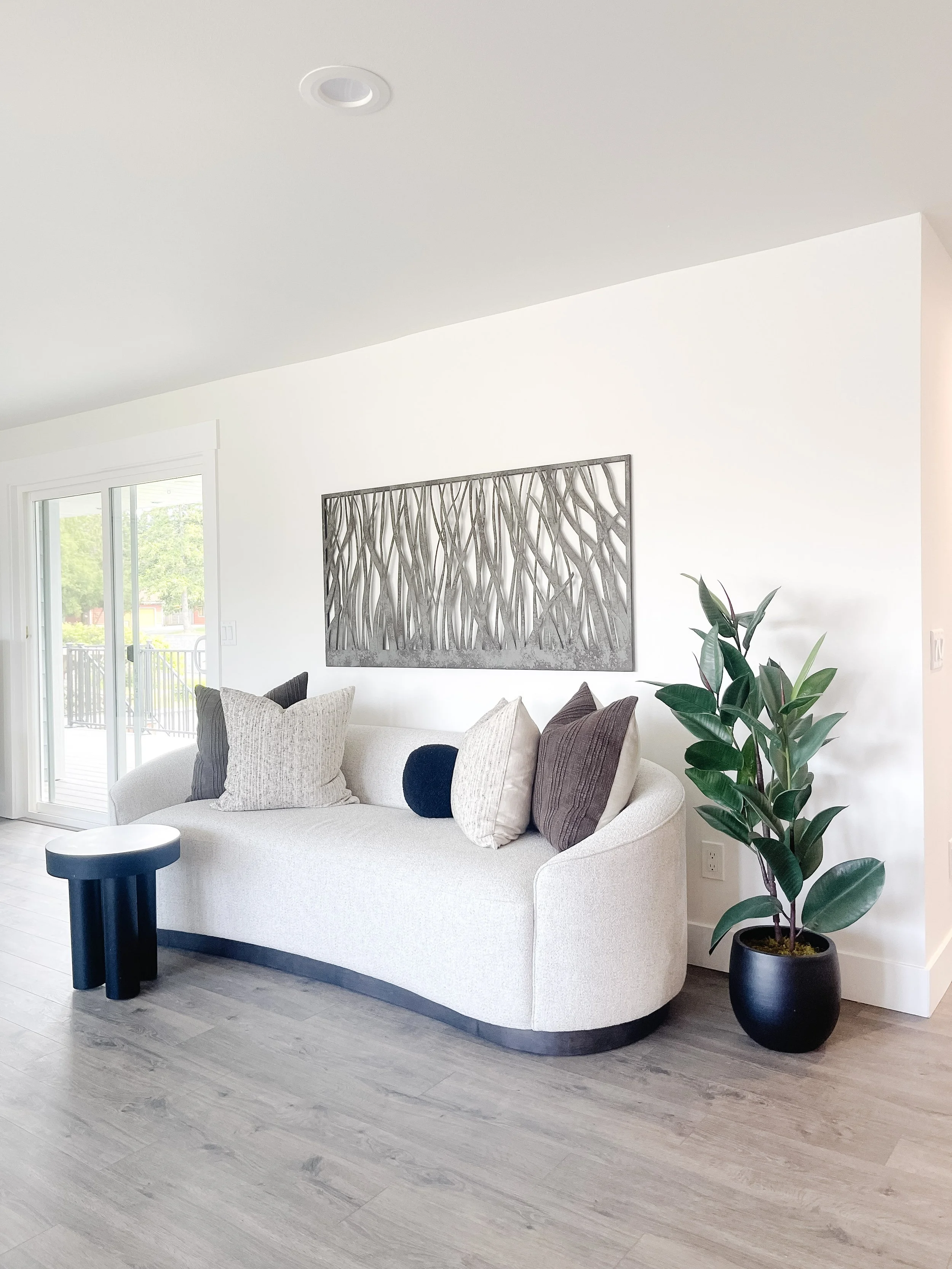 Bright staged living room in a Camano Island home with neutral sofa, layered textures, and large windows styled by Center Stage Home Design.