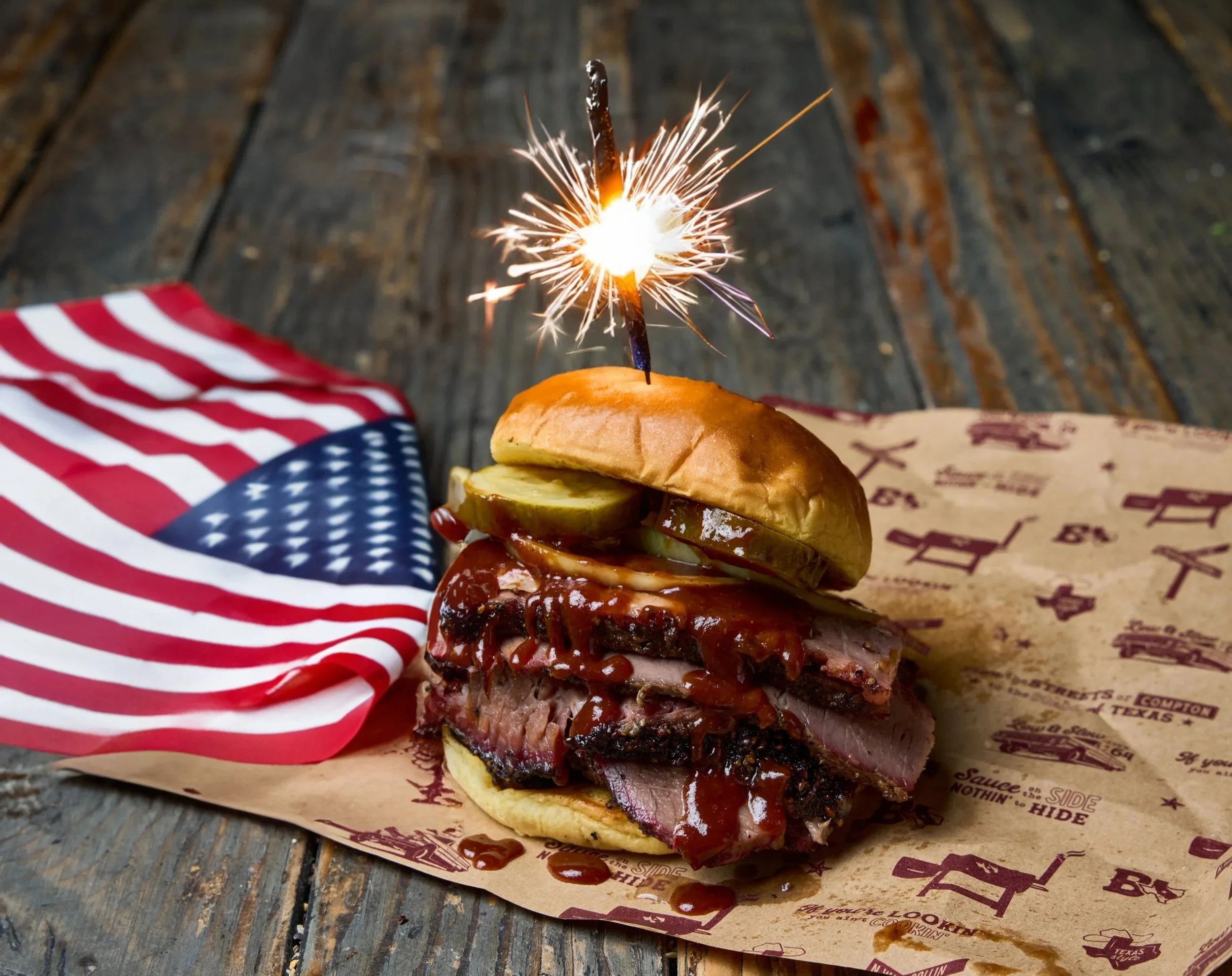 Bludso's BBQ brisket sandwich with a sparkler inserted for 4th of July