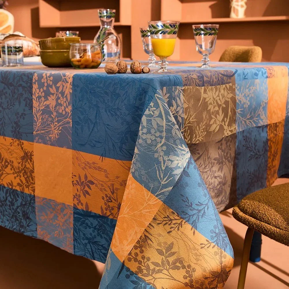 corner shot of blue and  yellow jacquard tablecloth on set dining table.