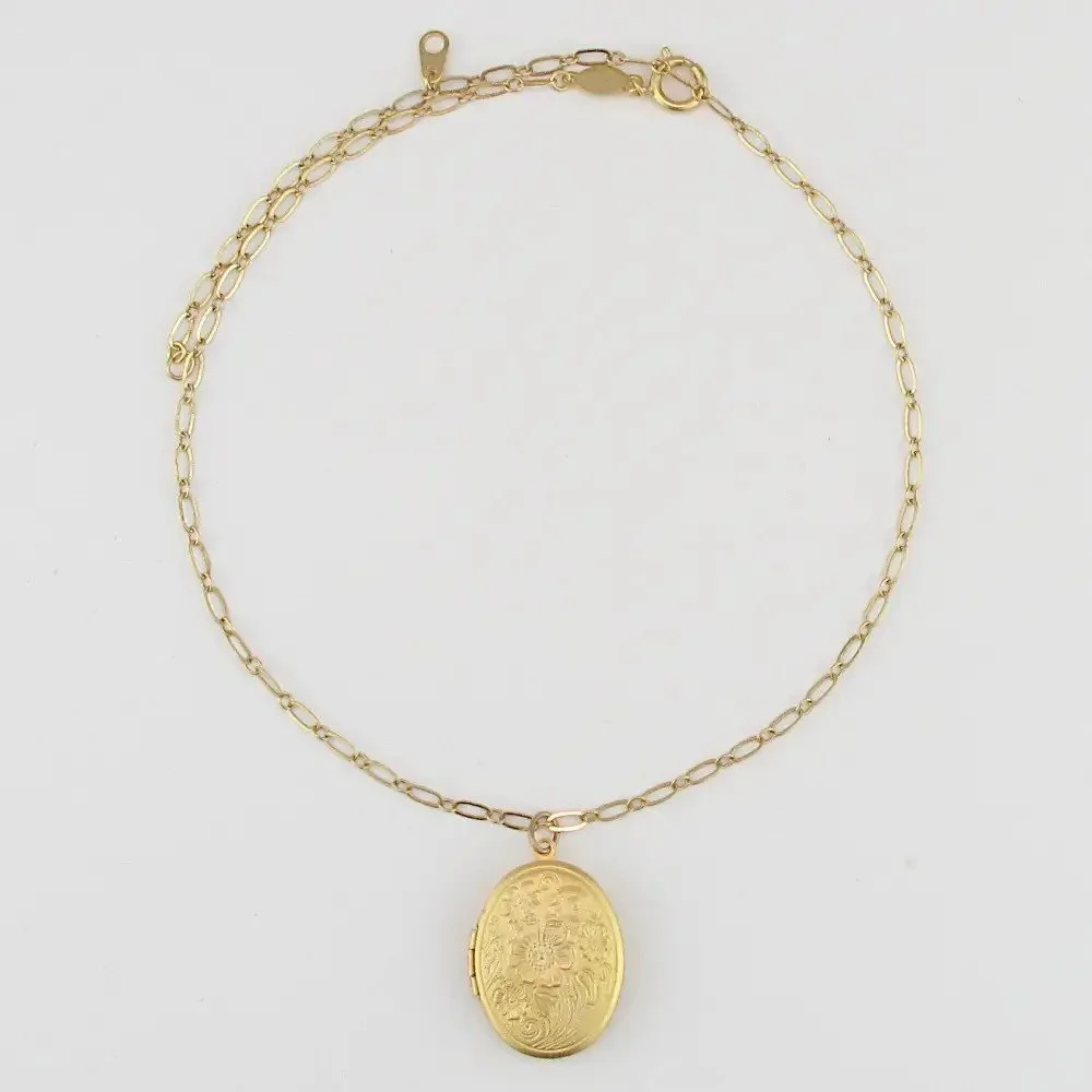gold chain necklace with oval locket pendant.