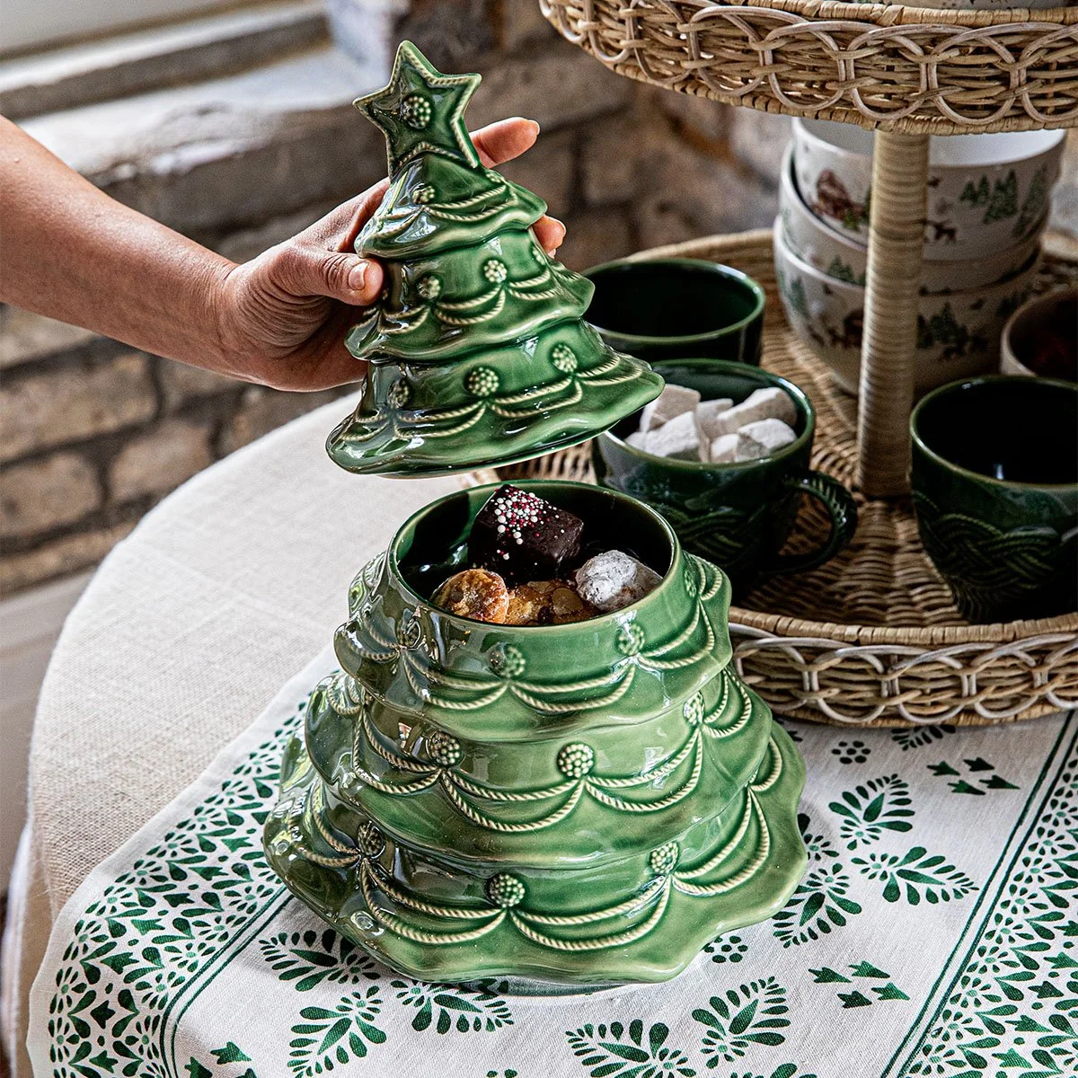 Christmas tree cookie jar on set table being opened to show sweets inside.