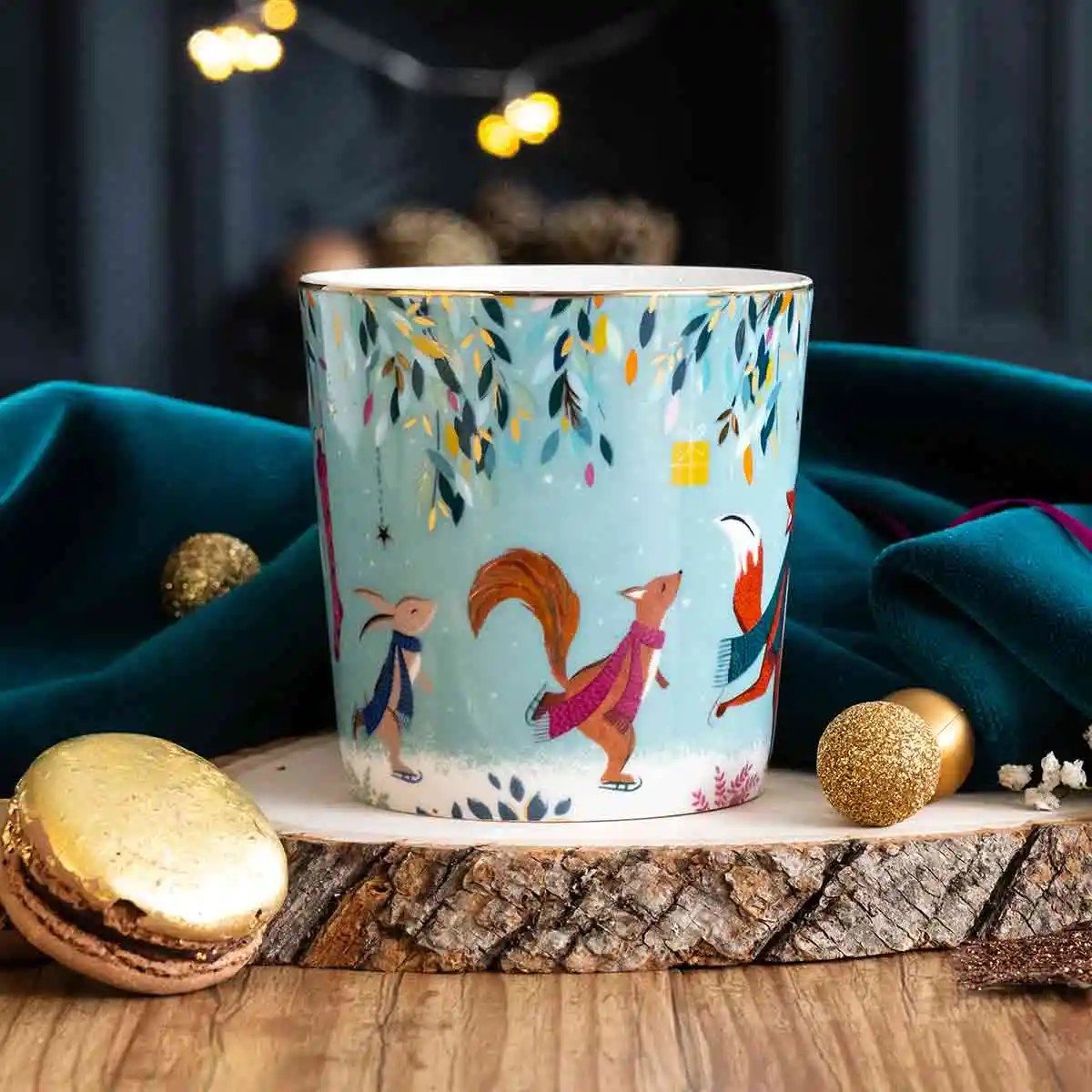 Aqua mug with ice skating woodland animals resting on wood plate.