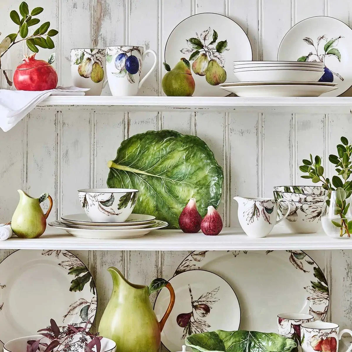 Leaf dish on display in cabinet with other dishes.