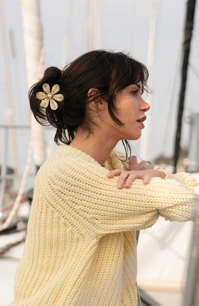 profile image of woman wearing floral claw clip in a casual twist-up hair do.