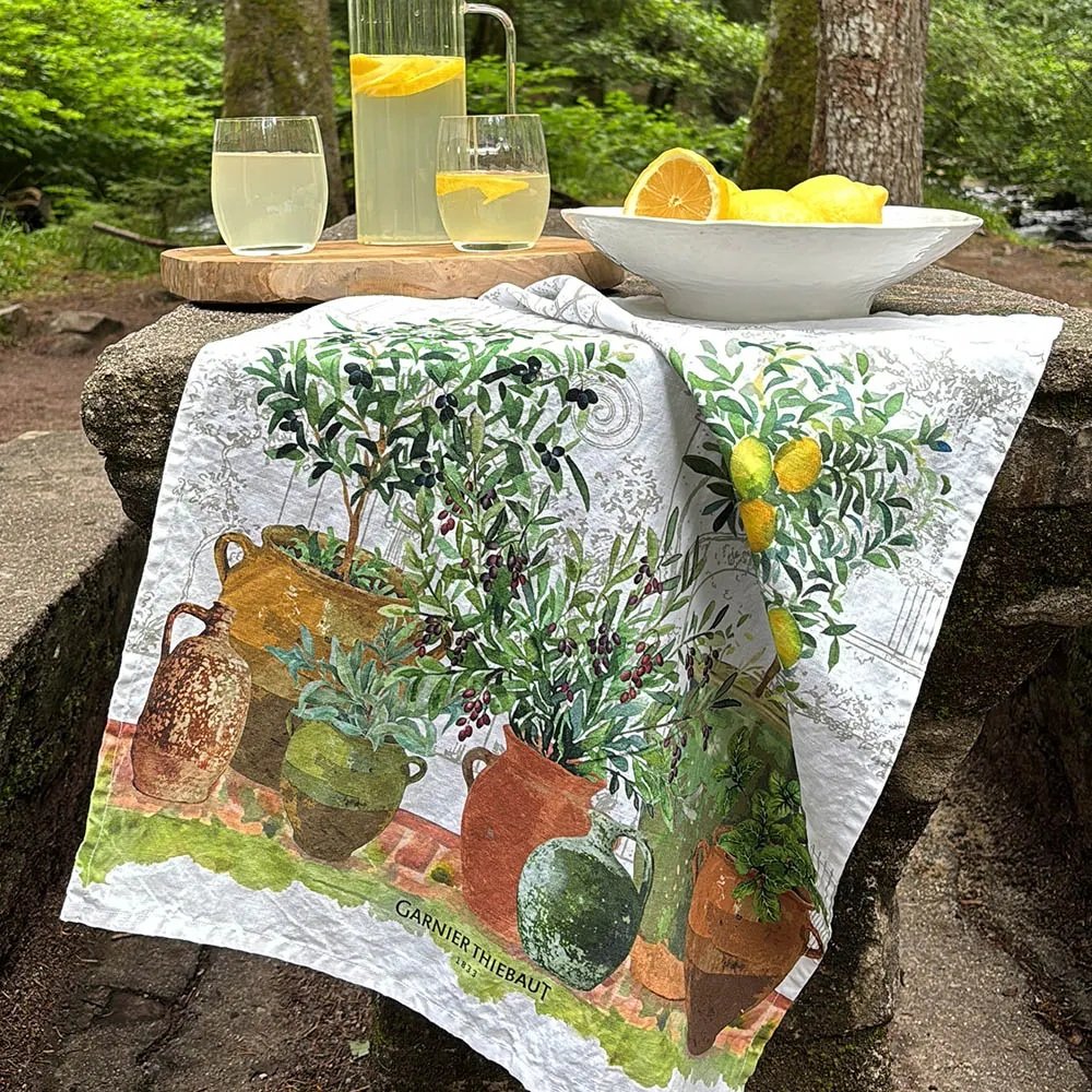 Jardin Provencal Olive Kitchen Towel hanging off table with lemons and glassware.