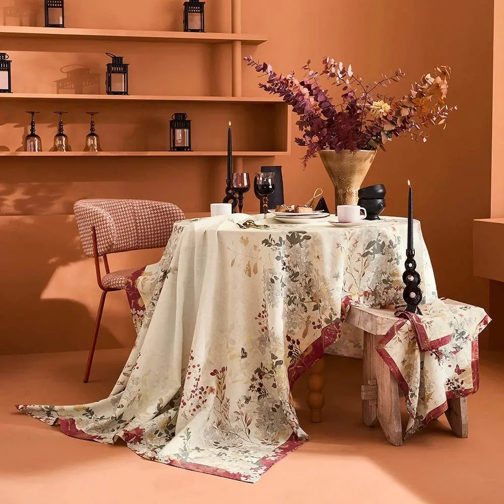 Vintage looking tablecloth with cream background and cranberry hued  border.