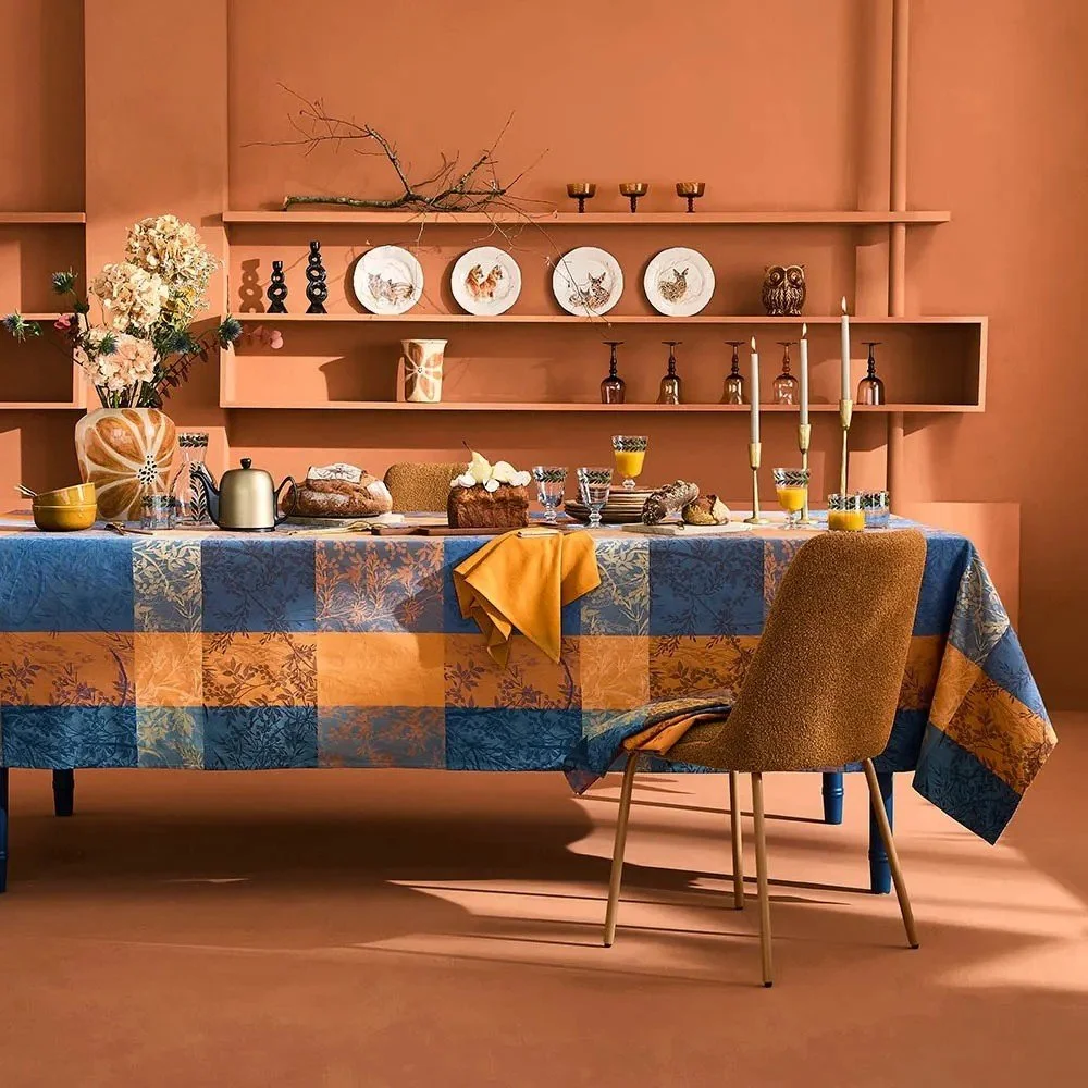 blue and yellow jacquard tablecloth on set dining table.