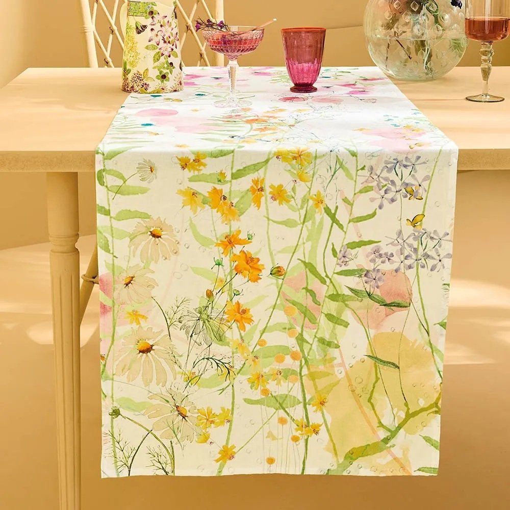 Pastel floral tablerunner on wood table with glassware.