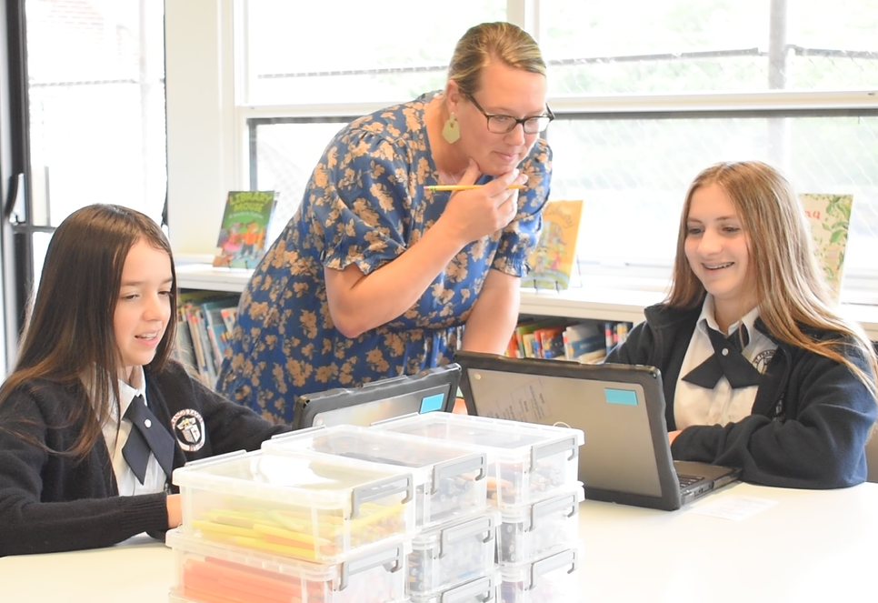 Librarian at St. Francis Xavier Catholic School in Birmingham, Alabama, assists students on computers