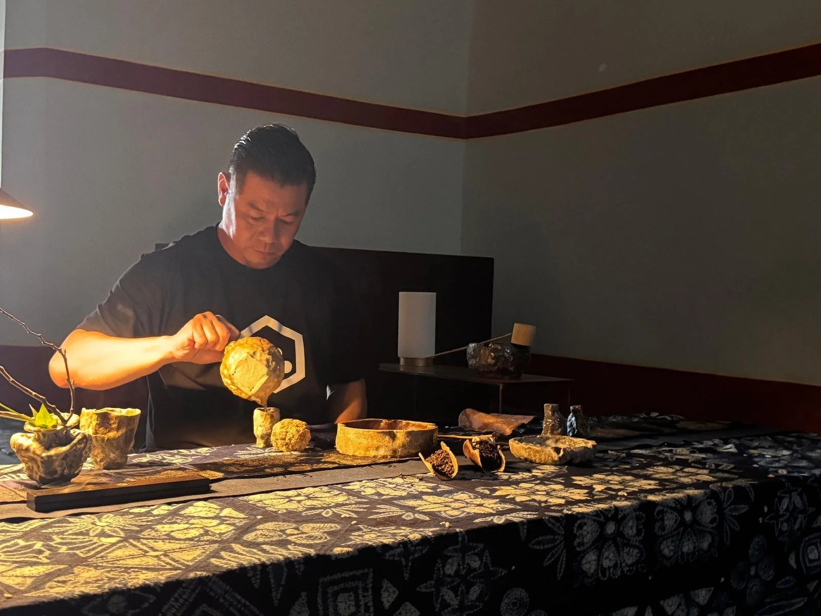 L'artista Alvin Ng duranter la cerimonia del tè per mini_ma gallery