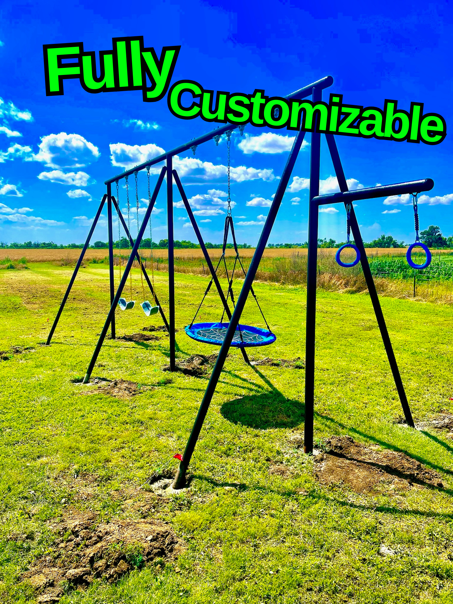Empty swing set and tire swing on a green field with blue sky and clouds